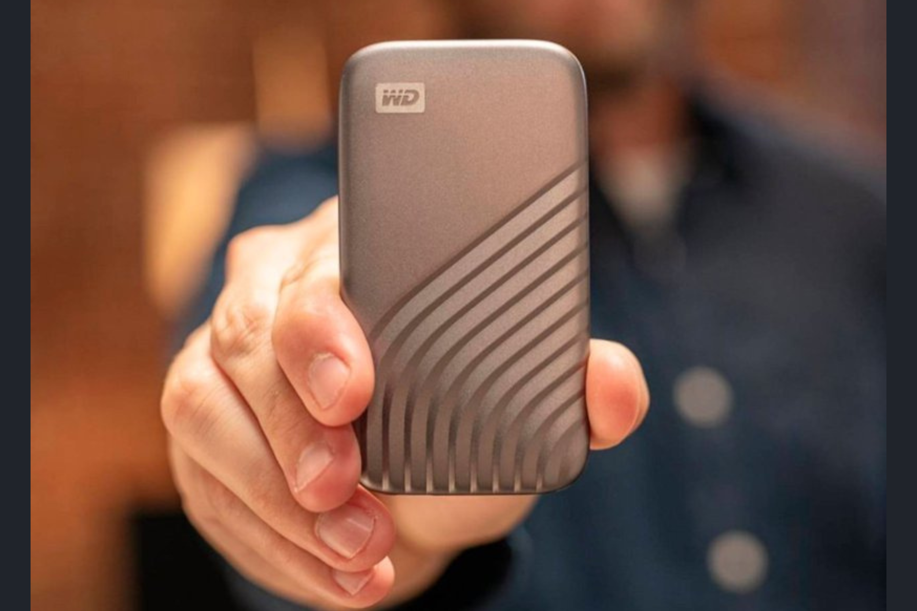 A man holding a WD My Passport 2TB External USB Type-C Portable SSD in Space Gray