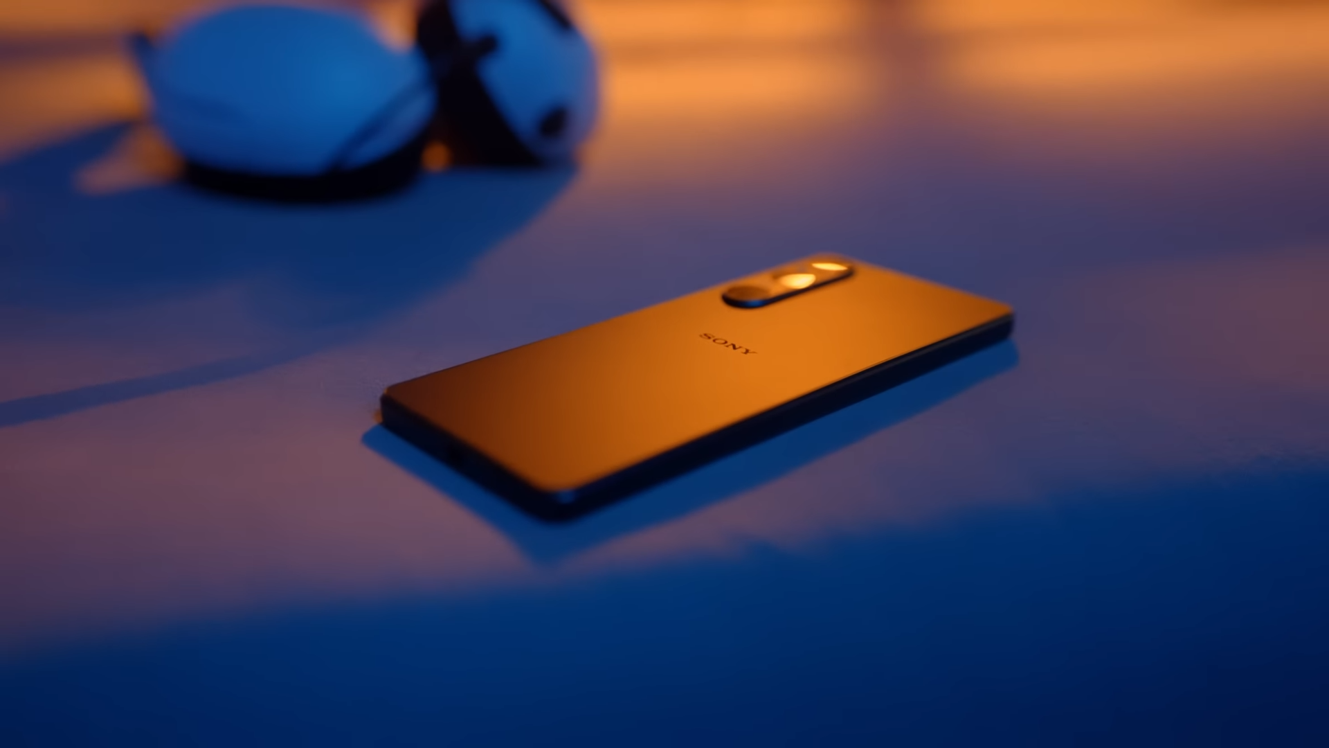 Sony Xperia 1 V laying on the table with orange and blue lights shining on it