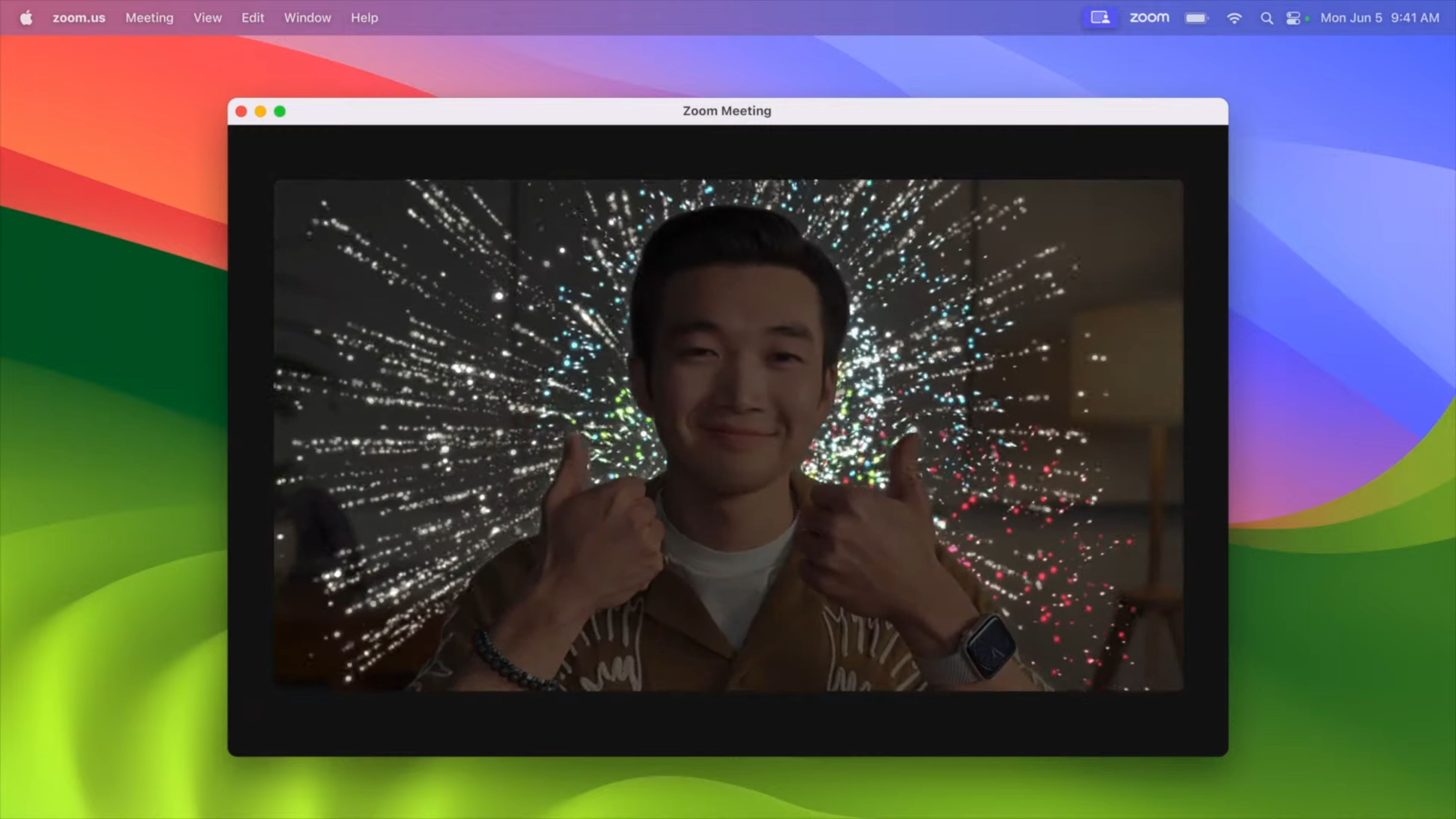 Screenshot von macOS Sonoma, das Feuerwerksanimationen anzeigt, wenn der Benutzer vor der Kamera eine Geste mit zwei Schlägen macht