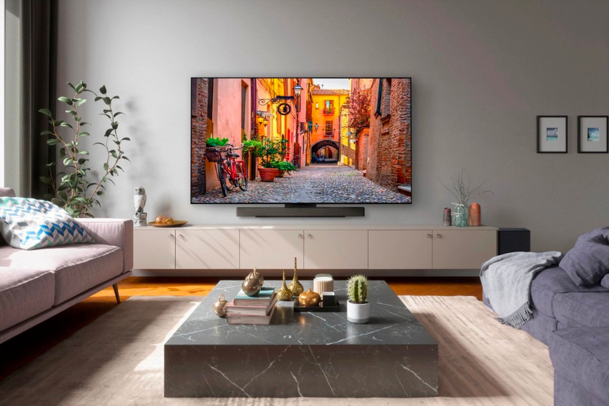An image showing the LG C3 OLED TV mounted on a wall in a living room with couches and other furniture.