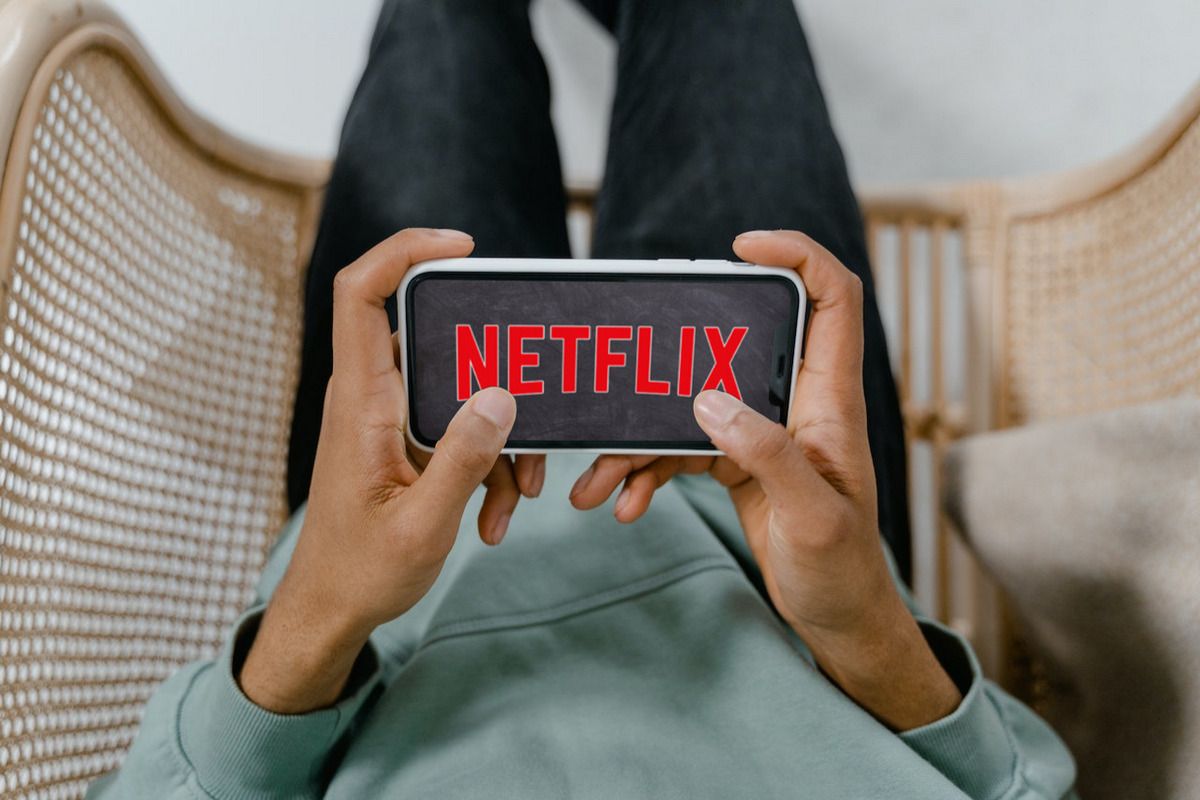 The Netflix logo displayed on a smartphone in a person's hand