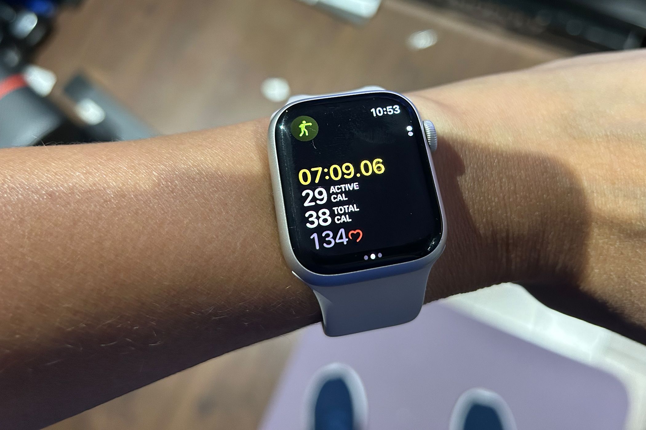 Eine Apple Watch am Handgelenk zeigt ein laufendes Training, die Herzfrequenzanzeige verblasst und daneben dreht sich ein kleines Herz.