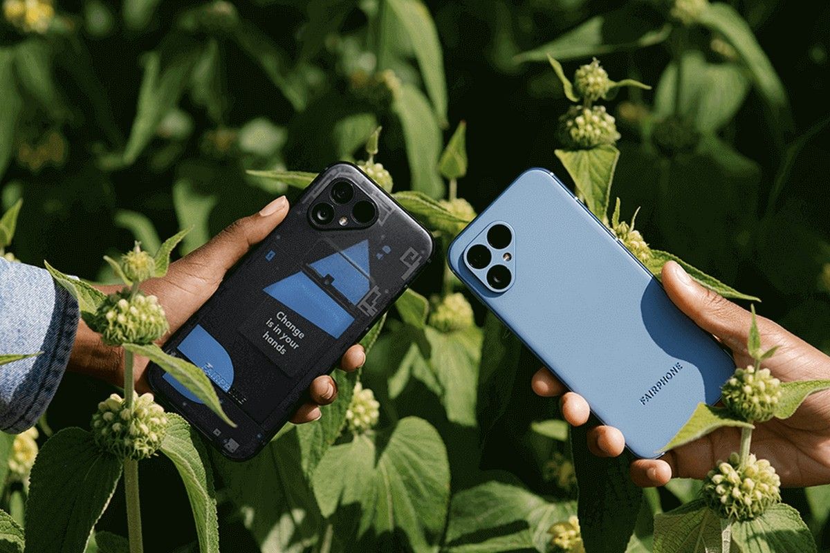 Two Fairphone 5 devices next to each other in people's hands, with green plants in the background