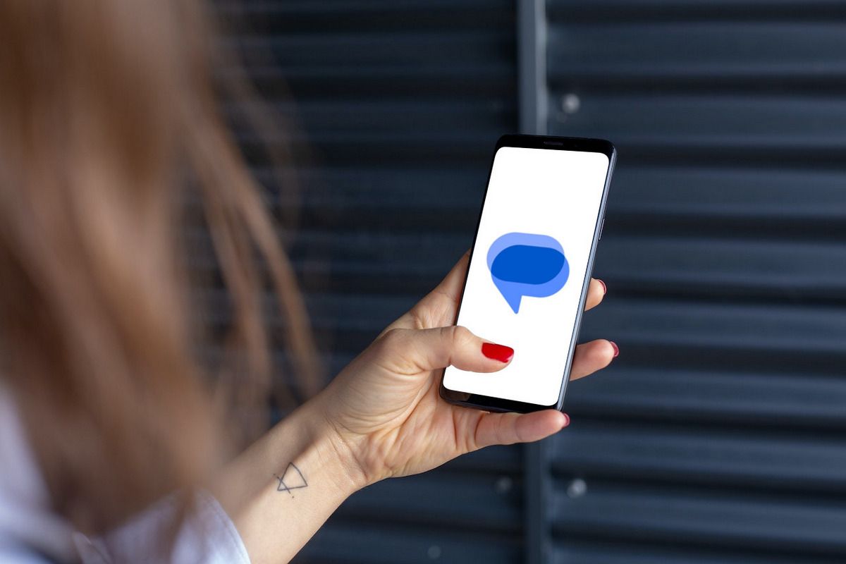 Persona que sostiene un teléfono inteligente Android con el logotipo de Google Messages en la pantalla