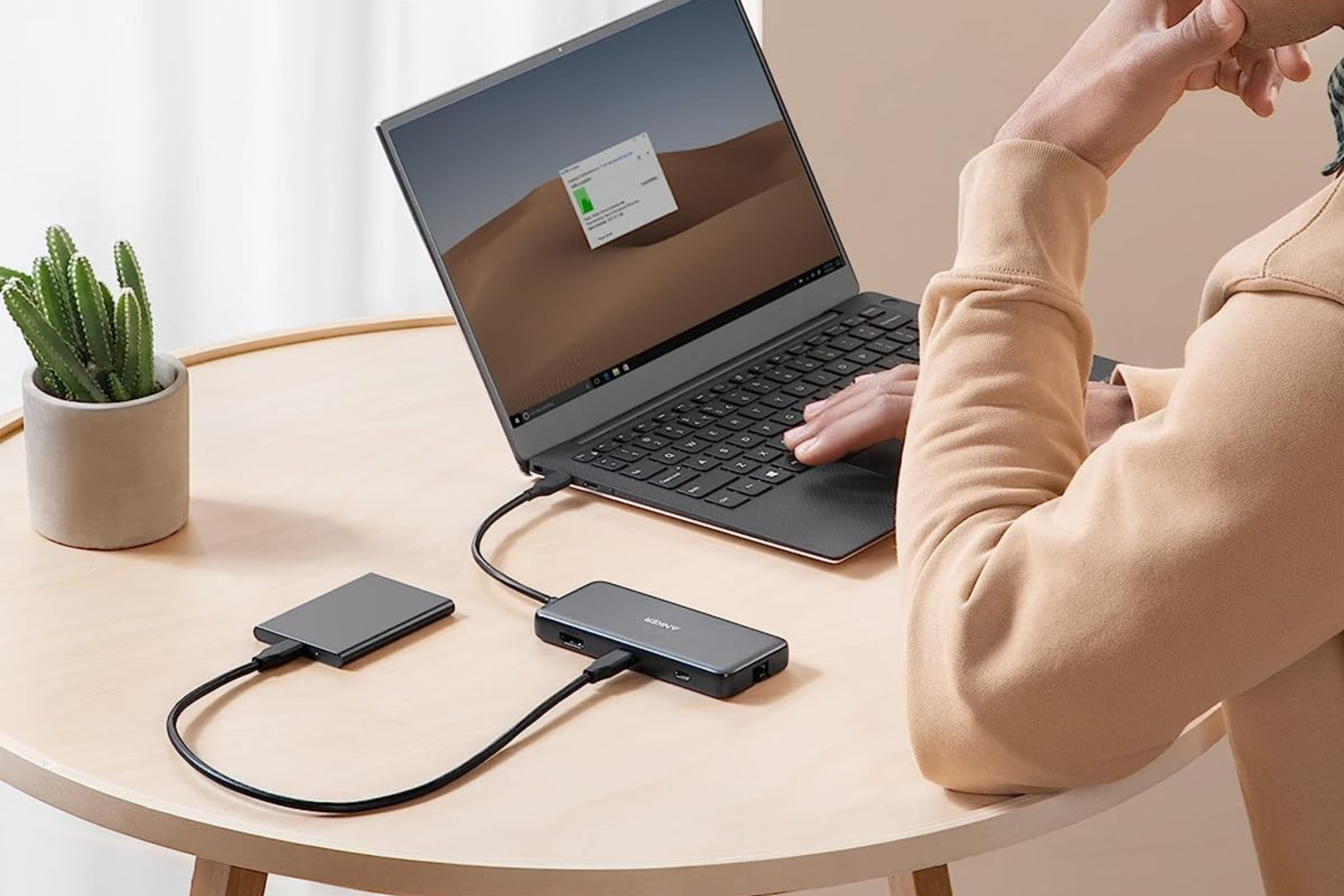 Anker 555 USB-C hub on table connected to laptop and external drive 