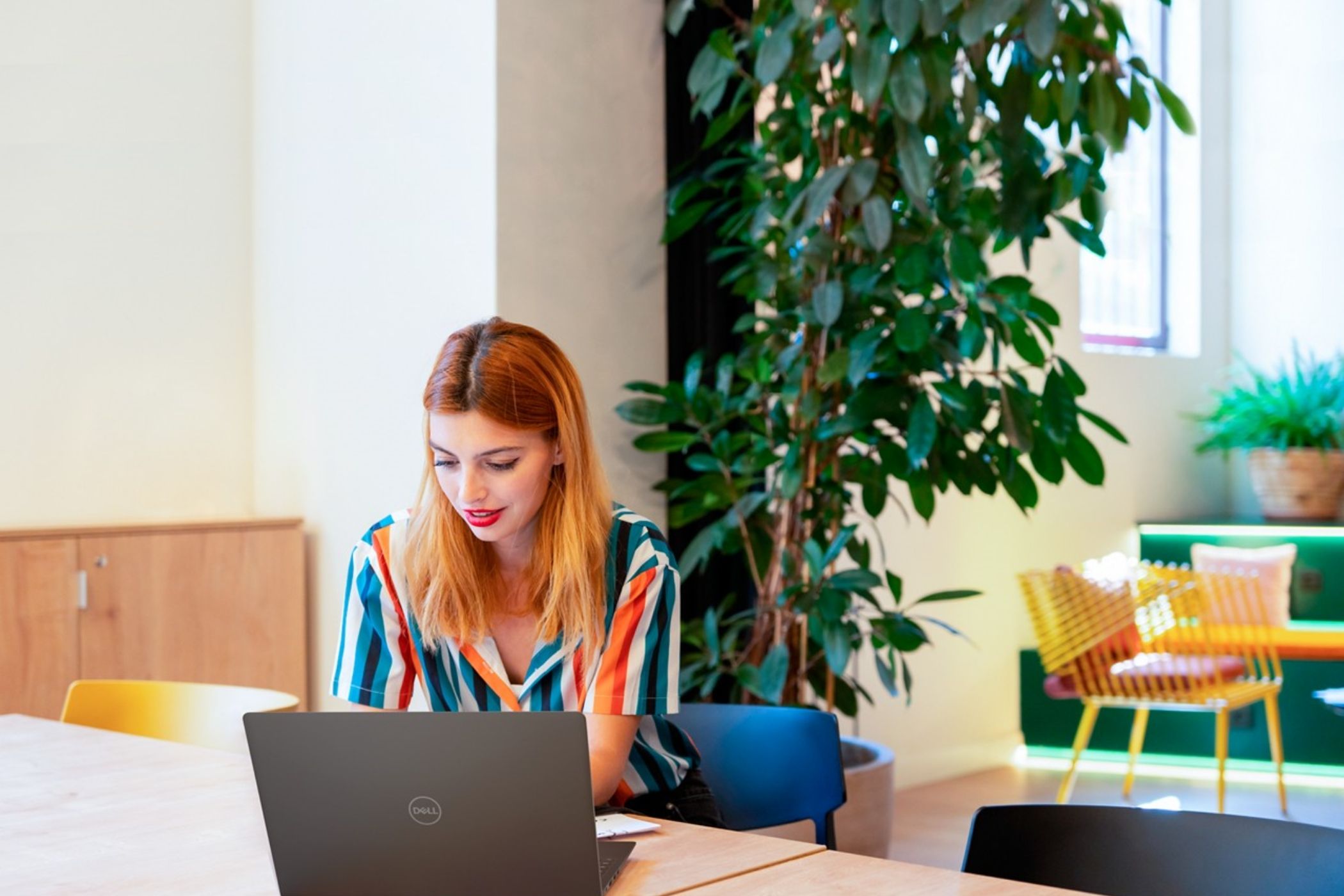 Mujer usando una computadora portátil Dell en una mesa