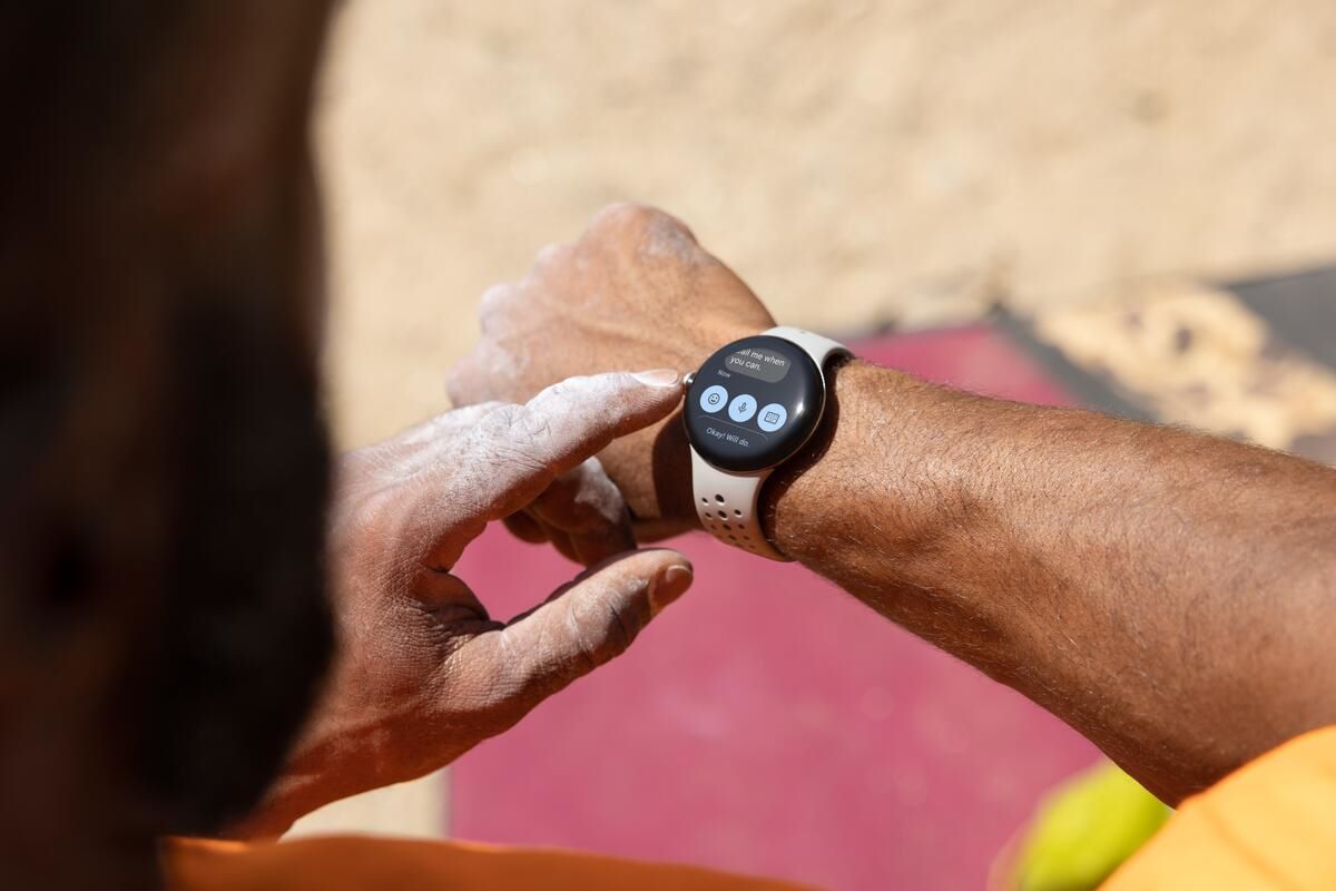 An image showing a person replying to a text on the Pixel Watch 2 amidst a workout on the beach.