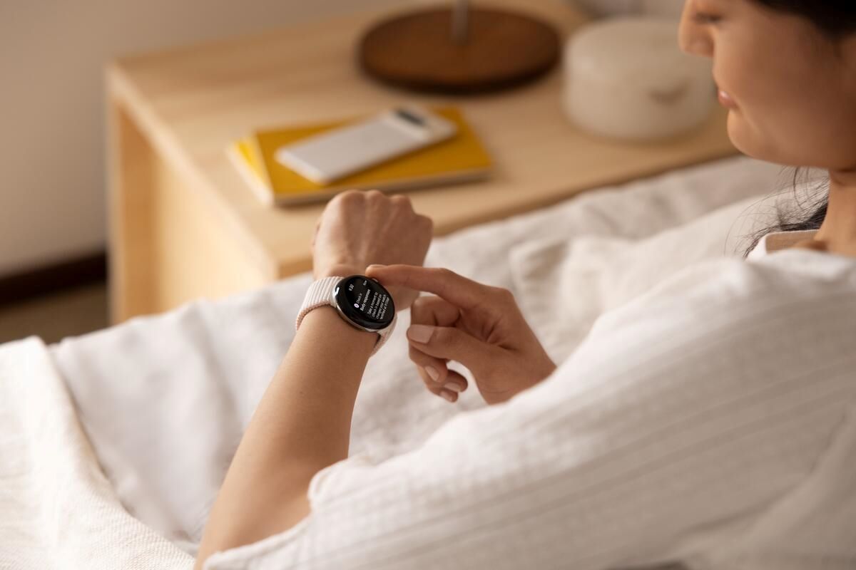 Изображение, на котором изображен человек, носящий Pixel Watch 2 на левой руке, глядя на дисплей.