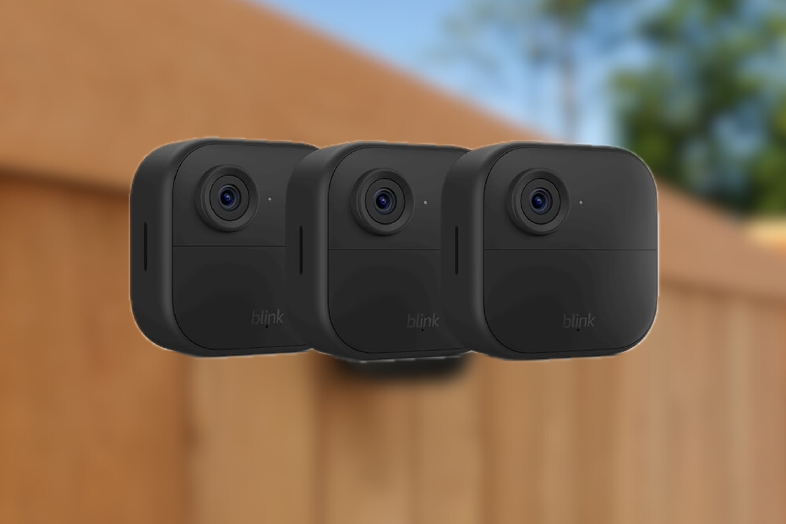 Blink Outdoor 4 camera 3-pack on blurred fence background