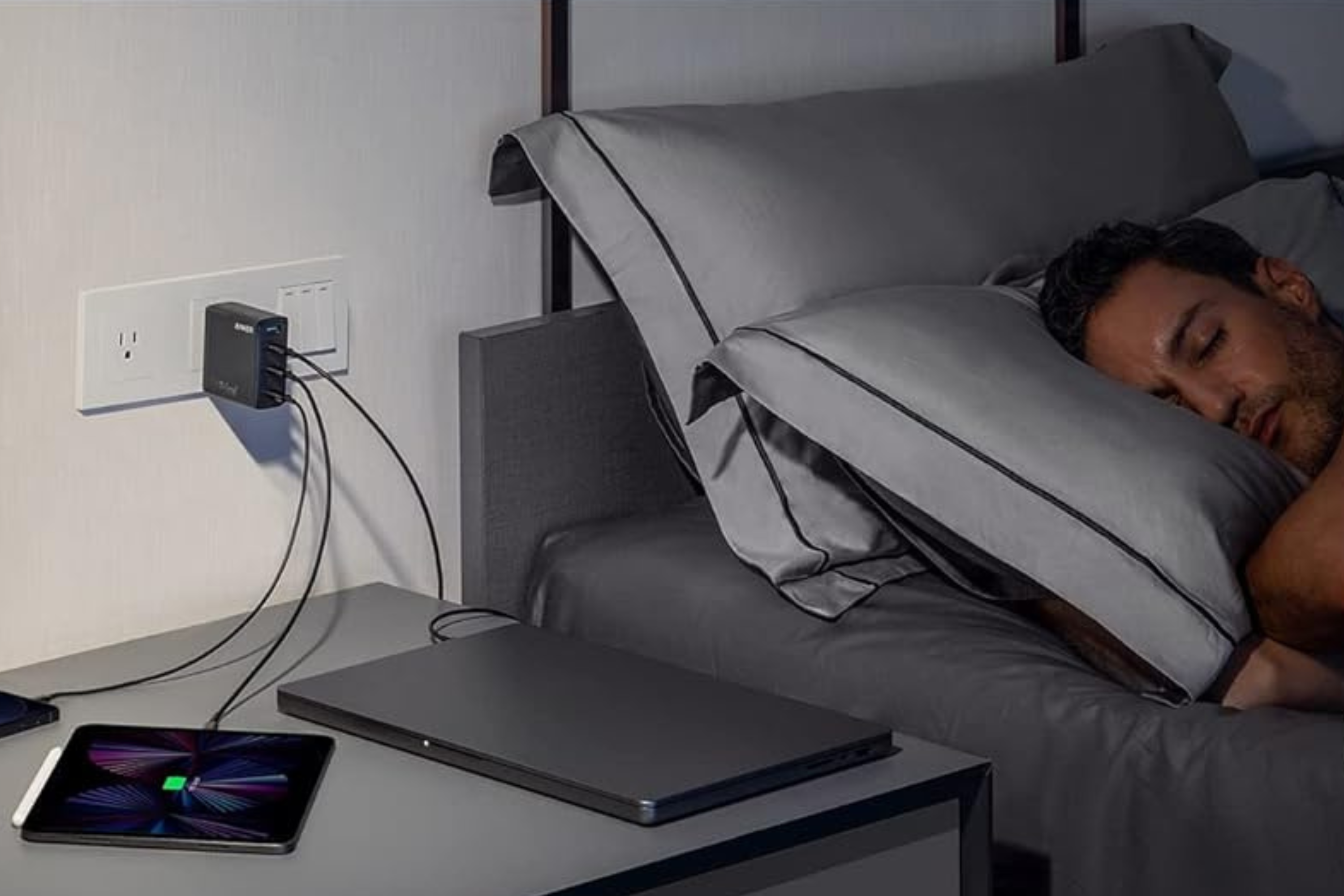 Anker 747 charger charging three devices while person next to it sleeps
