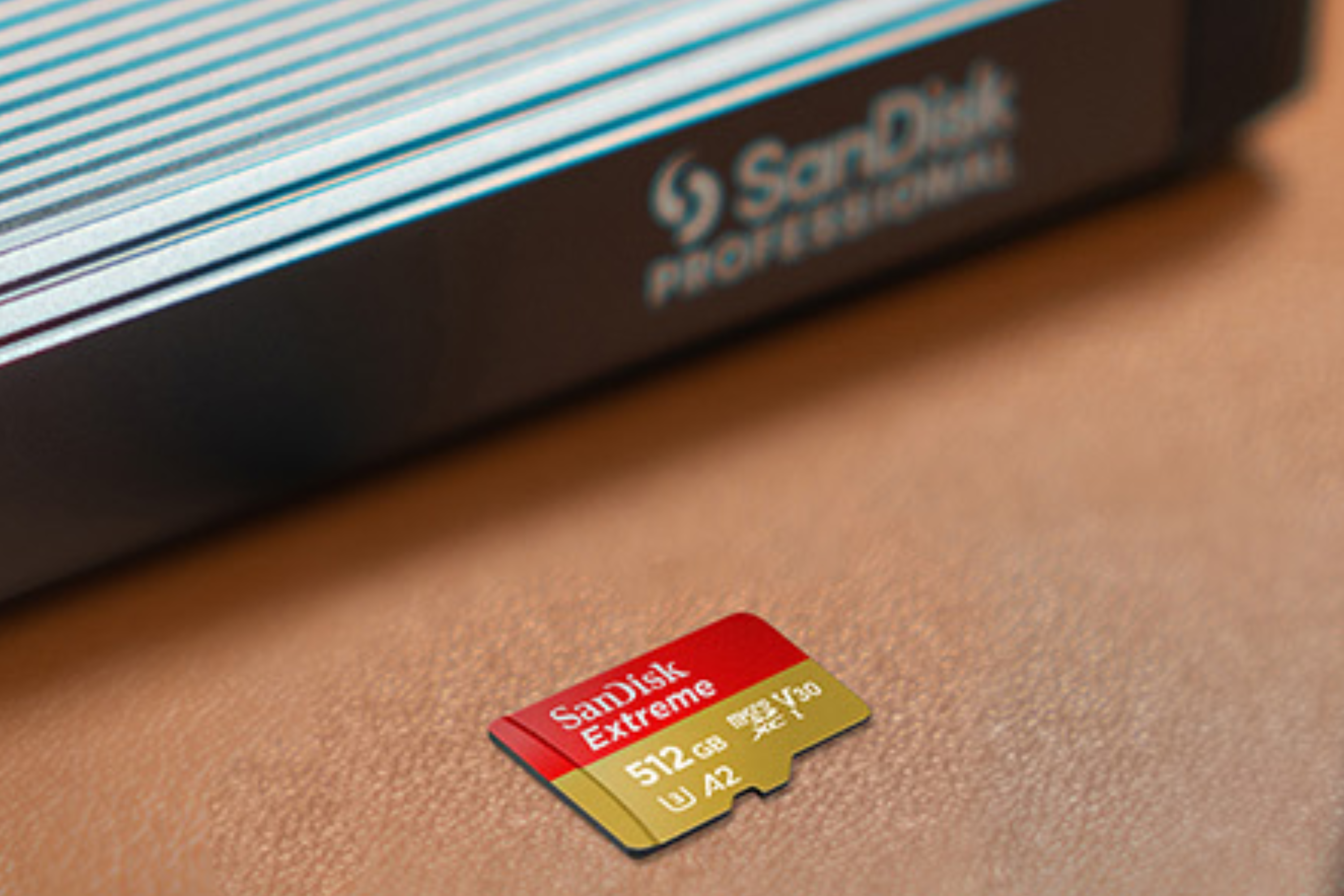A SanDisk Extreme 512GB microSDXC card on a table beside a card reader.