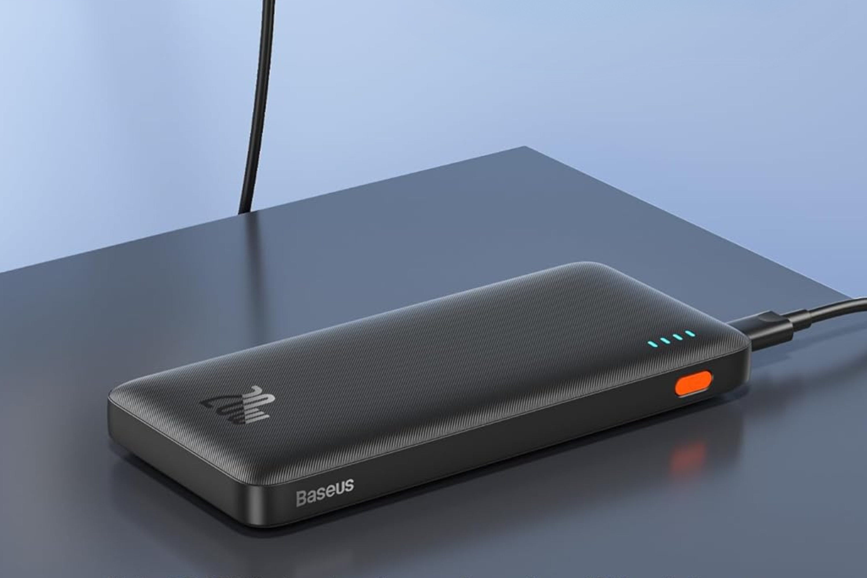 Baseus PD 20W 10000mAh Slim Battery Pack plugged in and charging on a table 