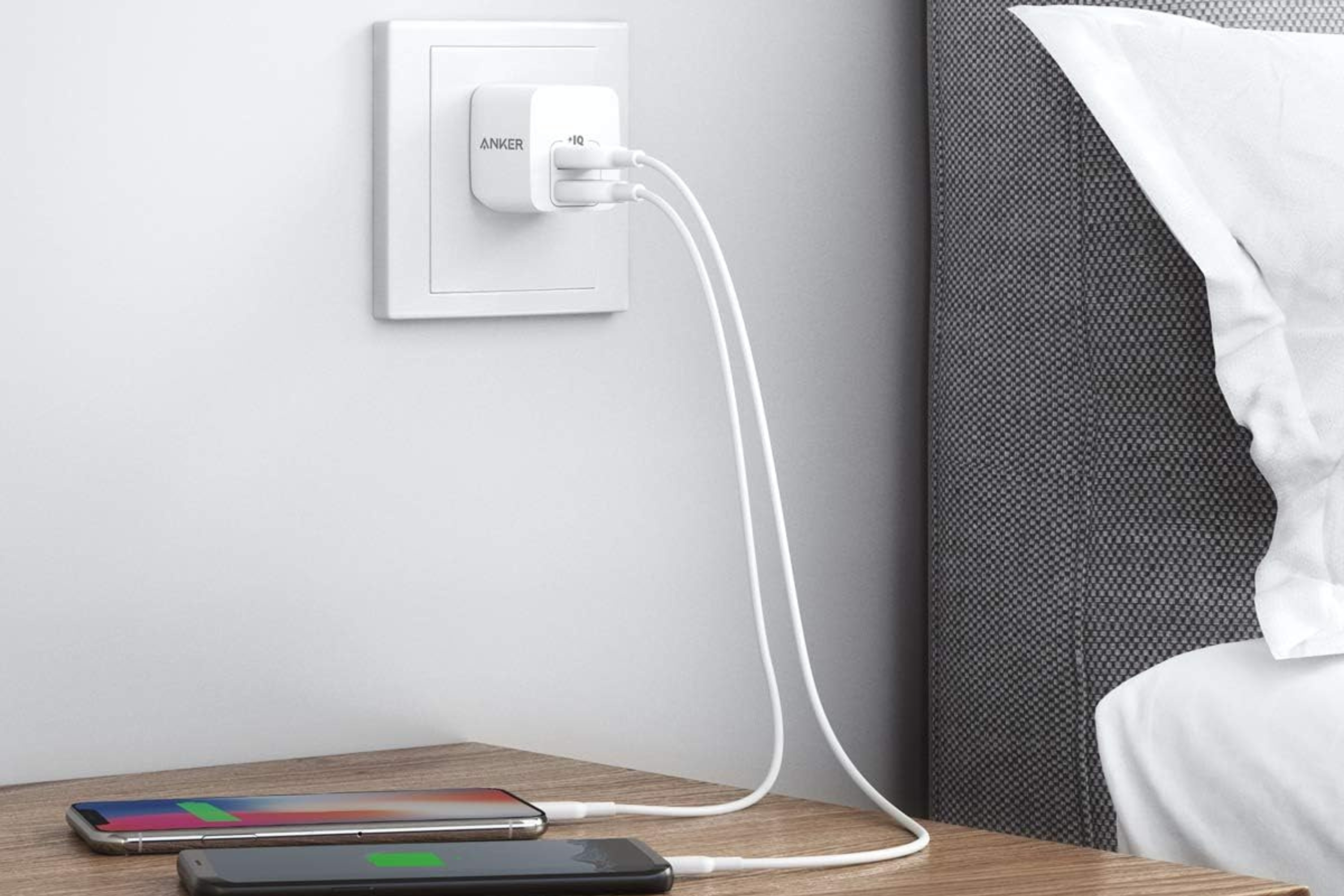 Anker charger plugged into wall charging two phones