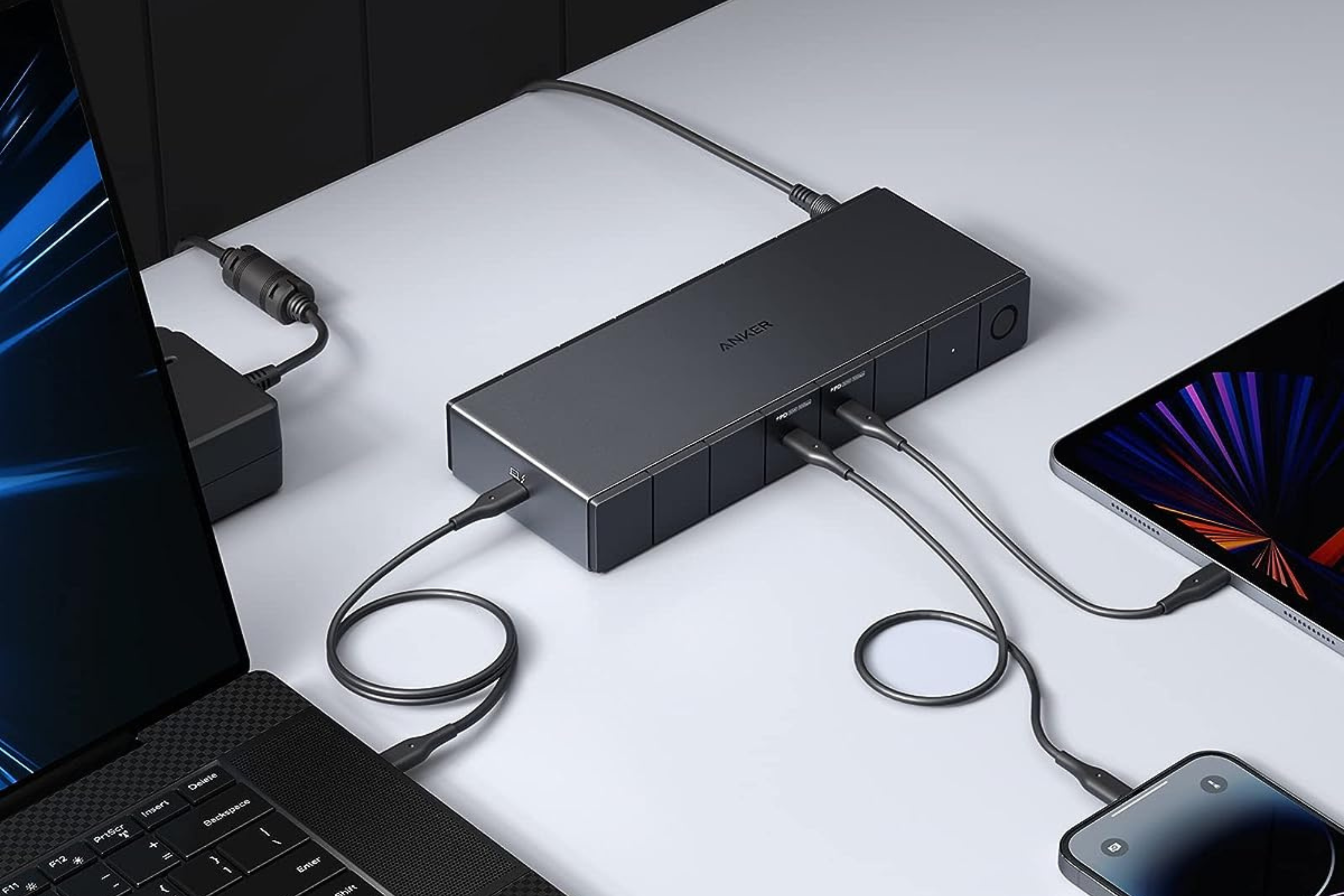 Anker 778 Thunderbolt Docking Station on table connected to laptop, tablet, and phone