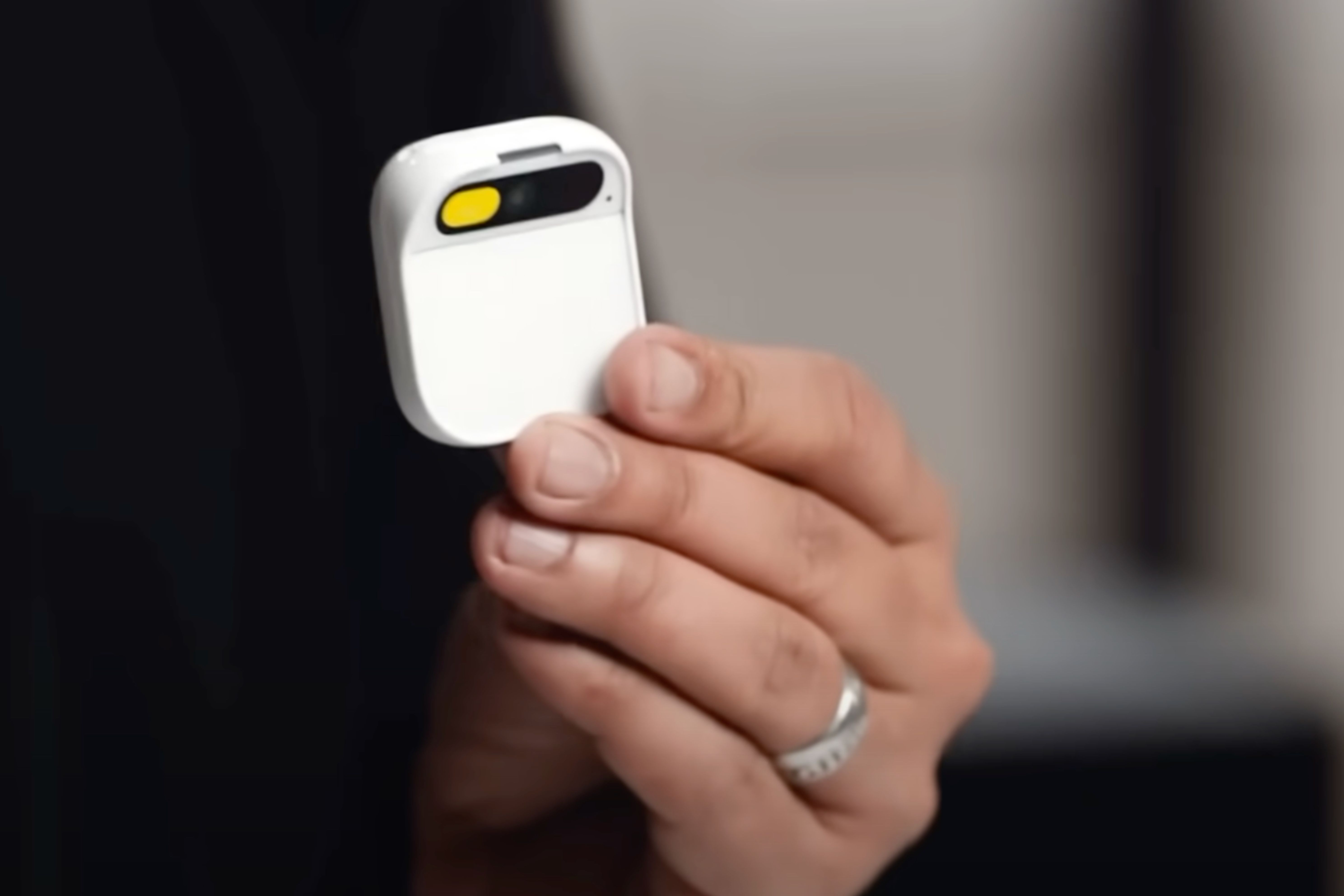 A person holding the Humane AI Pin.