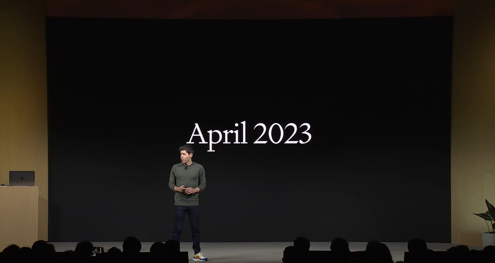 Captura de pantalla de la conferencia magistral de OpenAI con abril de 2023 de fondo