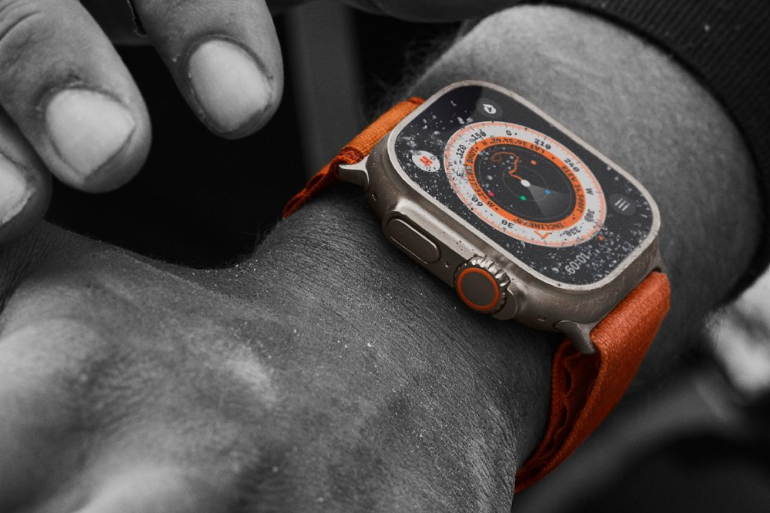 Apple Watch Ultra with orange band on wrist 