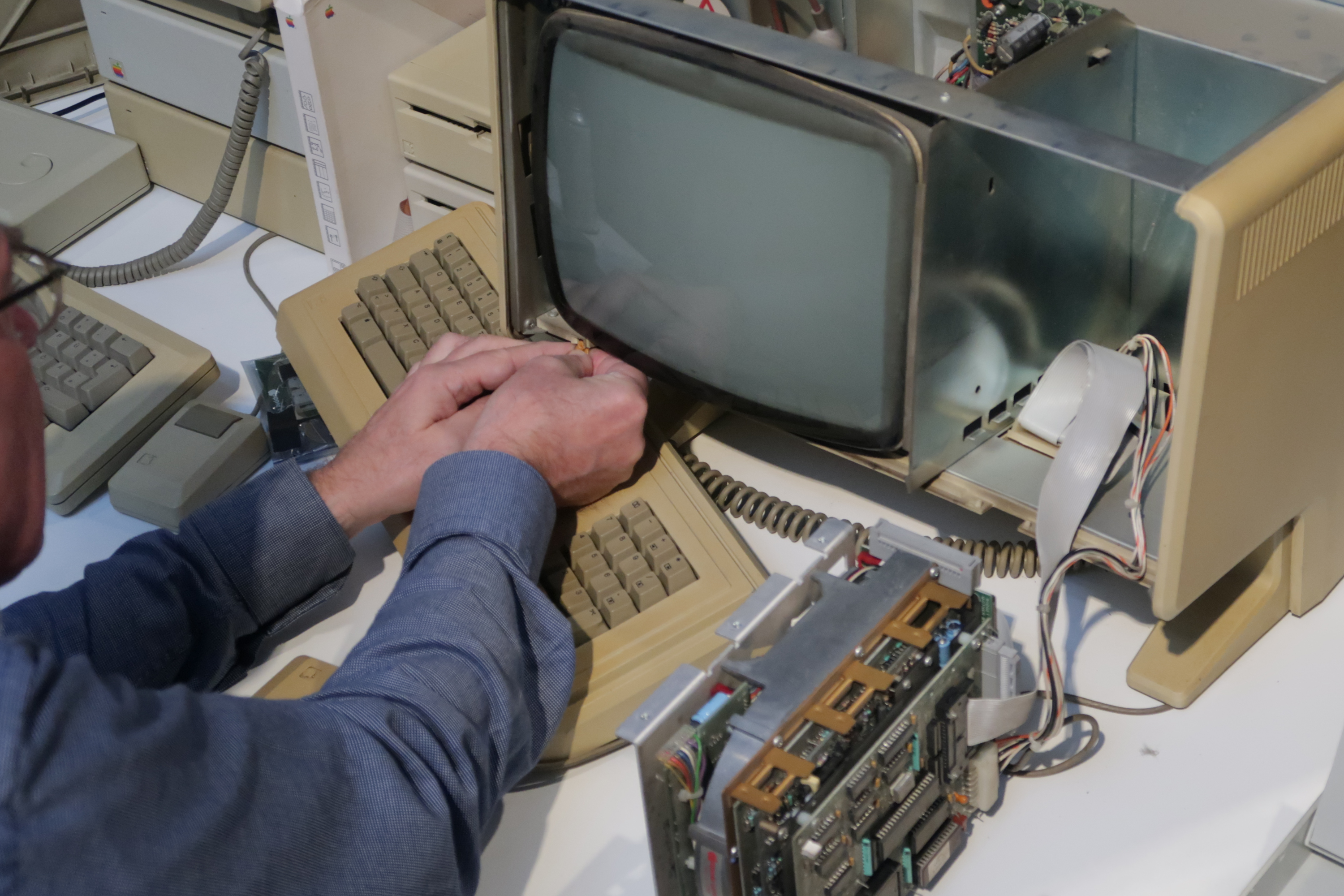 Un hombre reparando la computadora Apple Lisa.