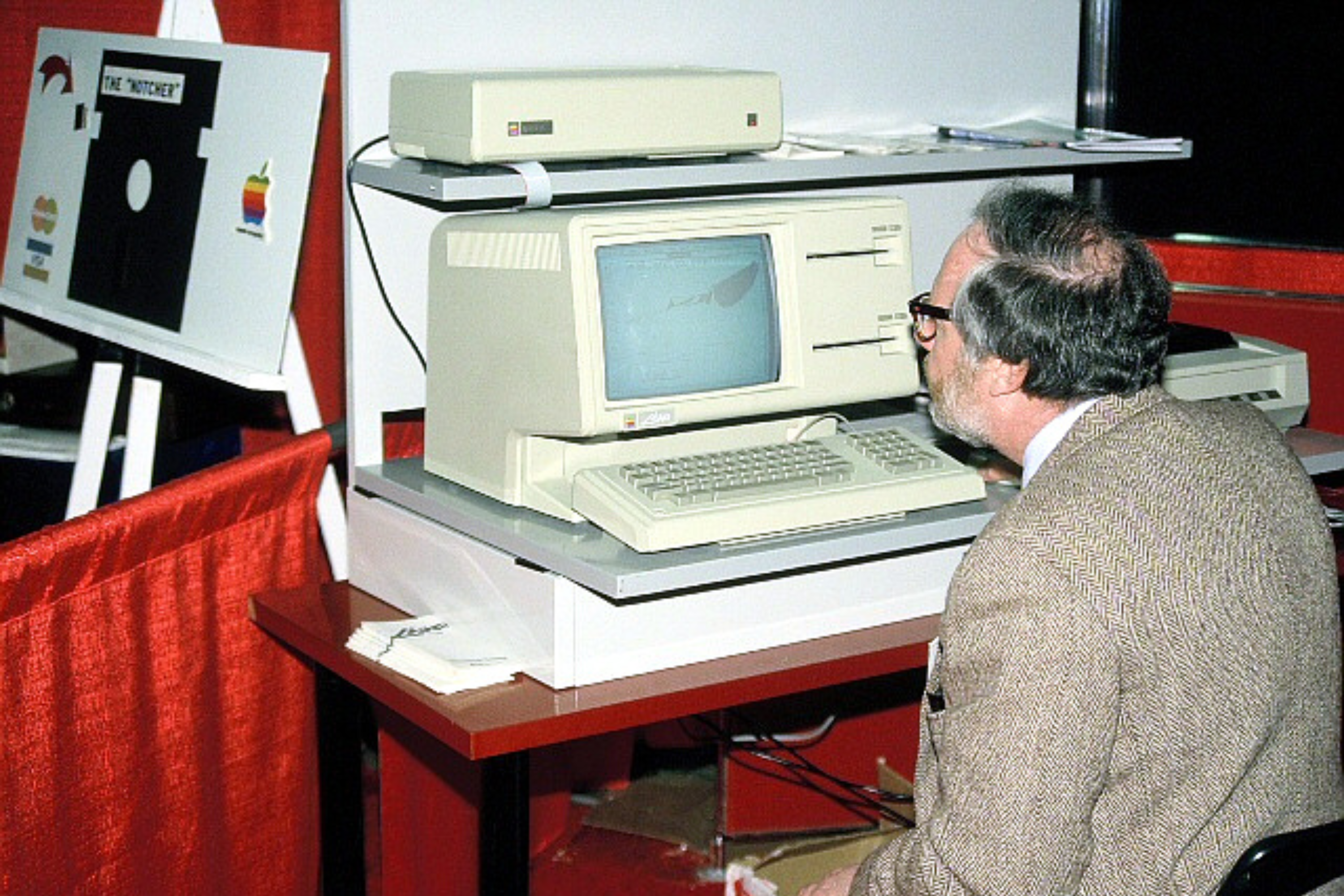 Una imagen de la computadora Apple Lisa en la Convención de Apple en Boston, un hombre está sentado frente a la computadora para probar cómo funciona.