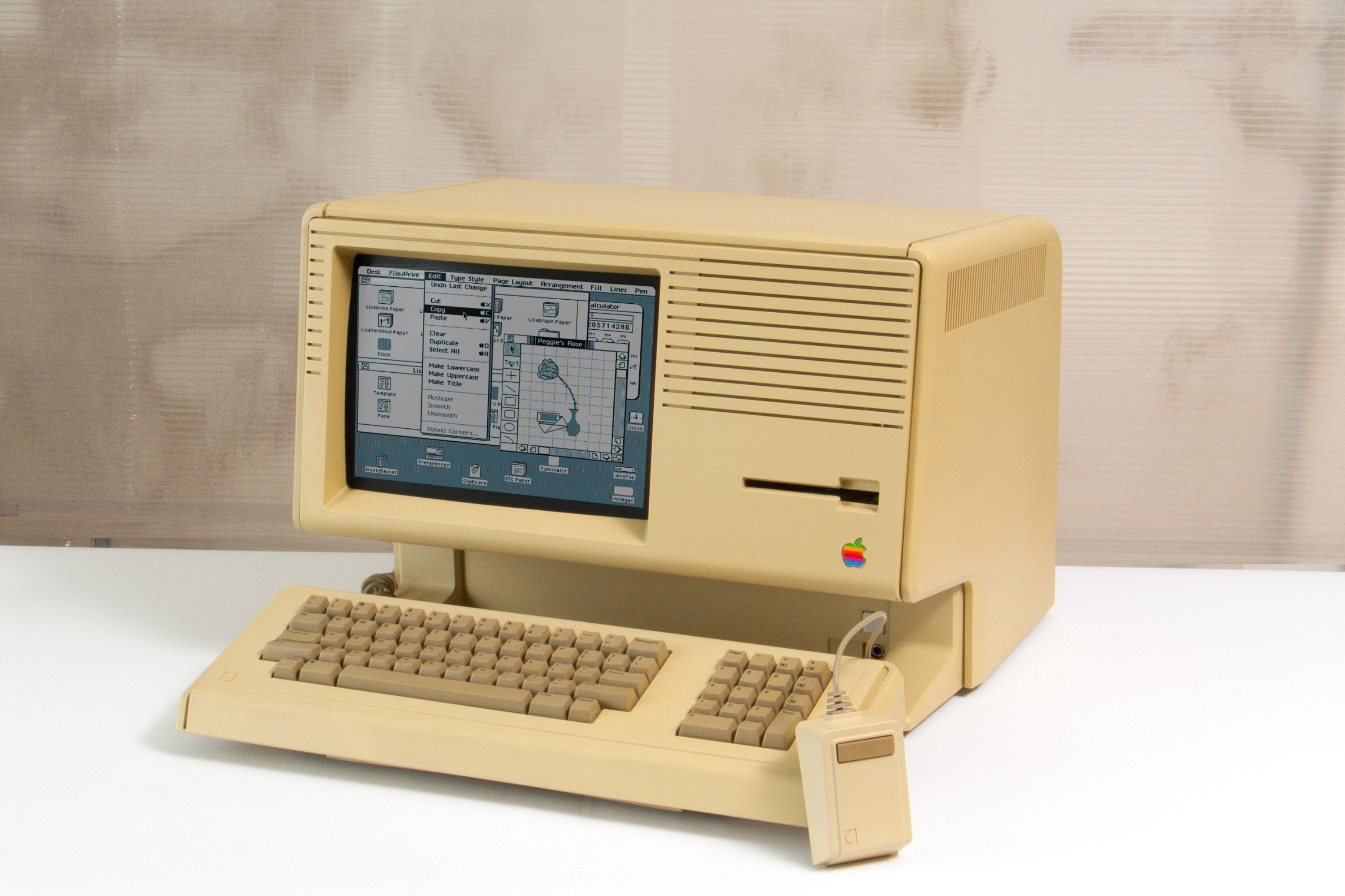 Una computadora Macintosh sobre un escritorio, en ángulo, mostrando la interfaz gráfica de usuario de la computadora.