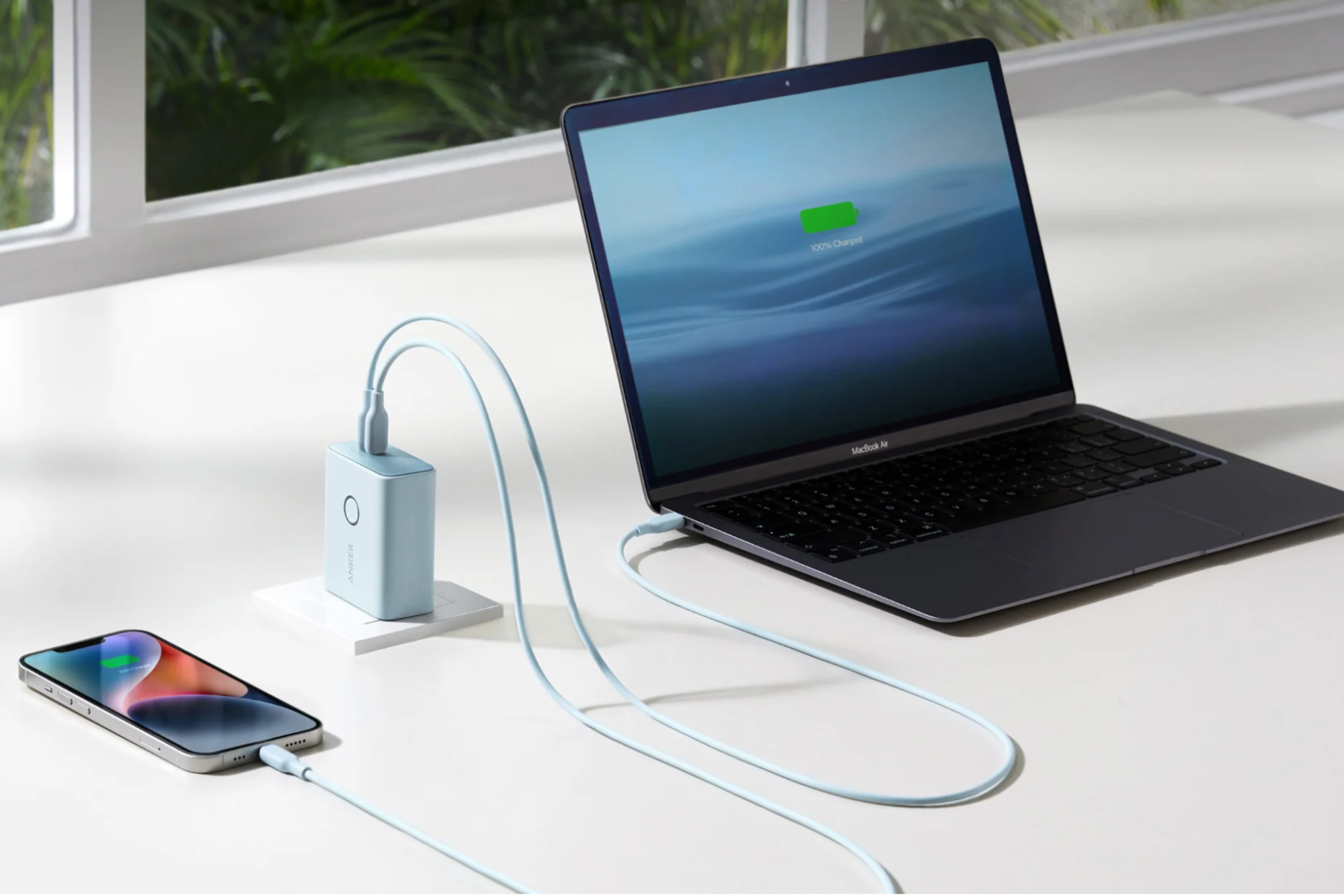  Laptop and smartphone on desk charging with Anker 521 Power Bank charger 