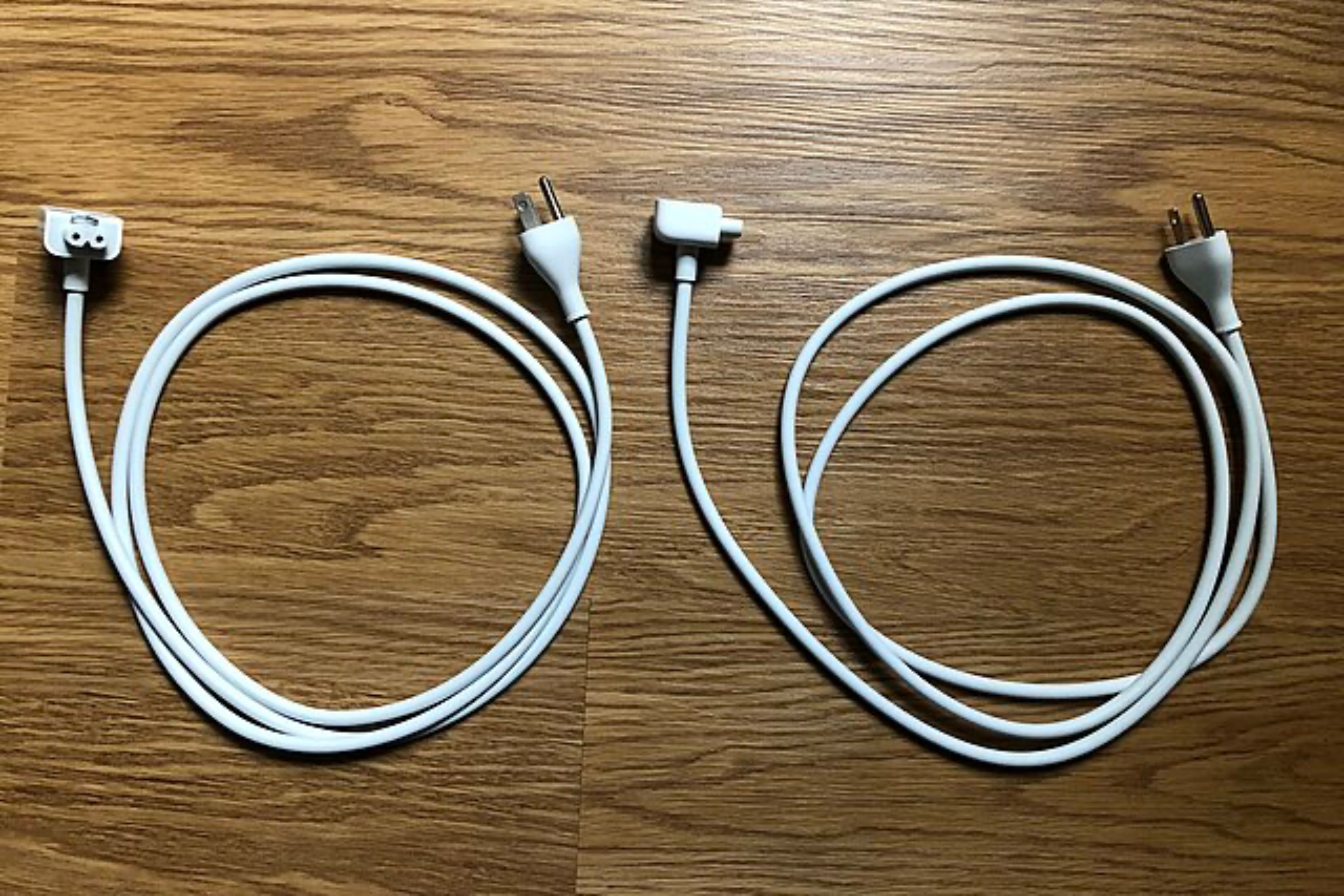 Two Apple power adapter extension cables on the floor.