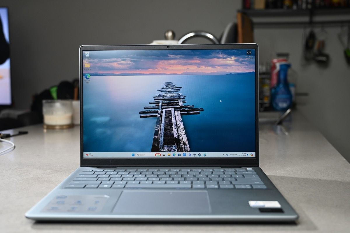 Open Dell Inspiron 14 Plus 7440 with a picture of a dock over water during sunrise.