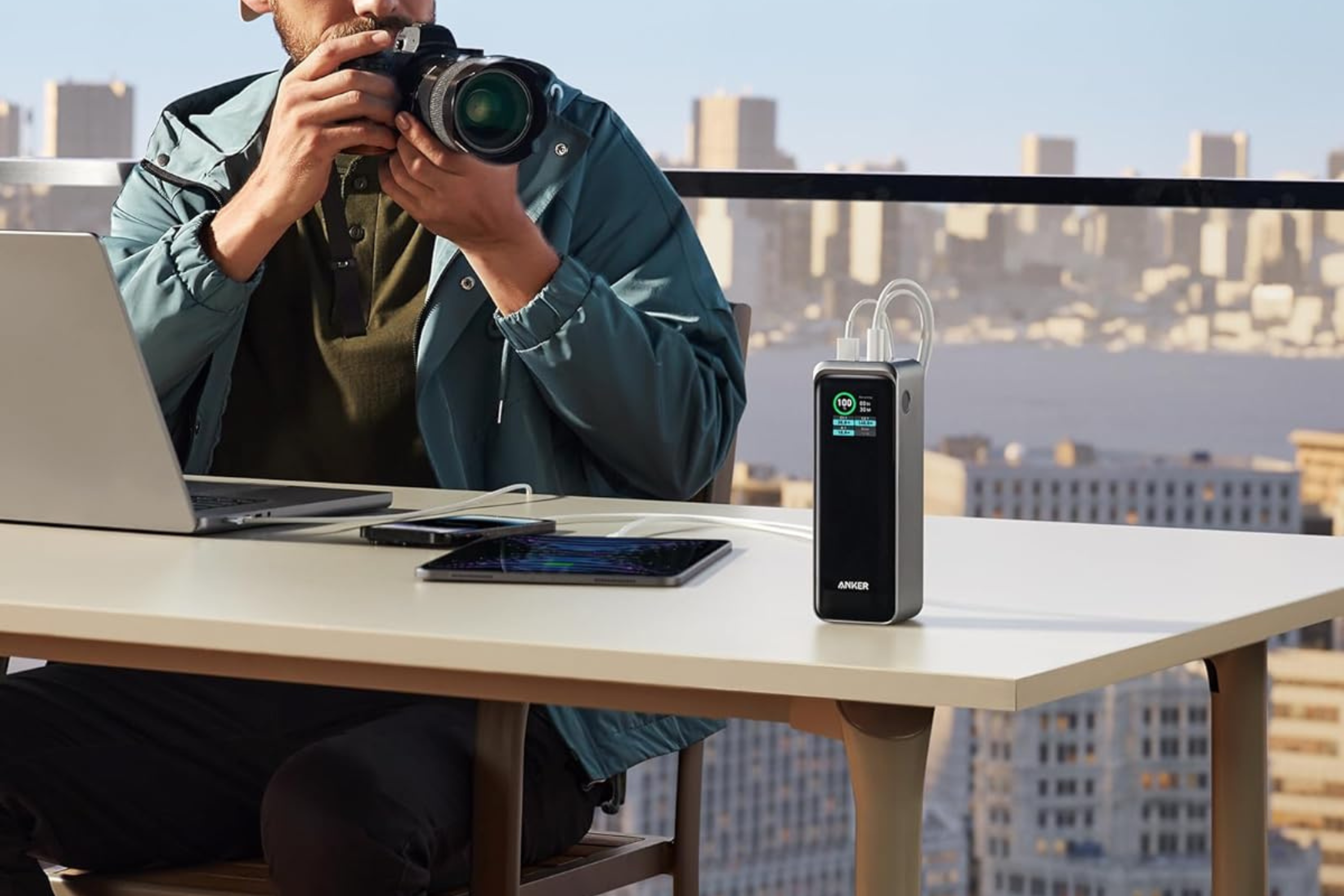 Anker Prime Power Bank, cargador portátil de 27 650 mAh, 3 puertos y 250 W sobre la mesa que carga tres dispositivos a la vez