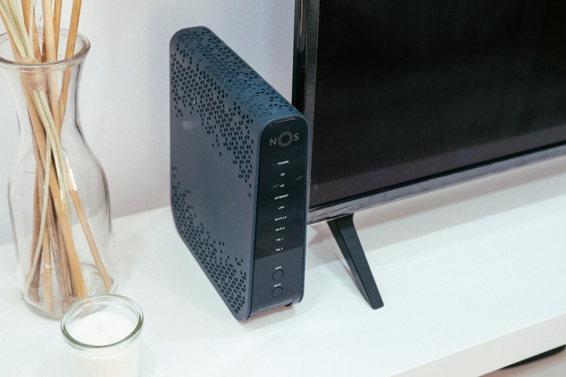 A router next to a television and incense sticks