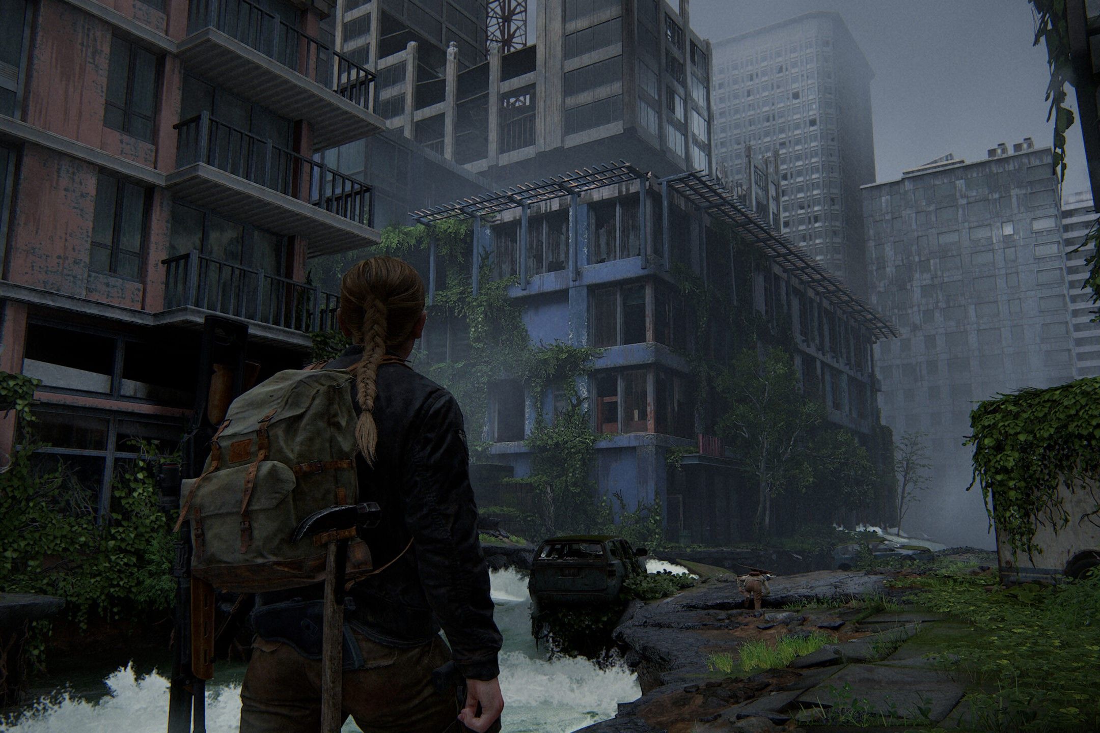 Captura de pantalla de The Last of Us Part II que muestra a Abby caminando por la ciudad.