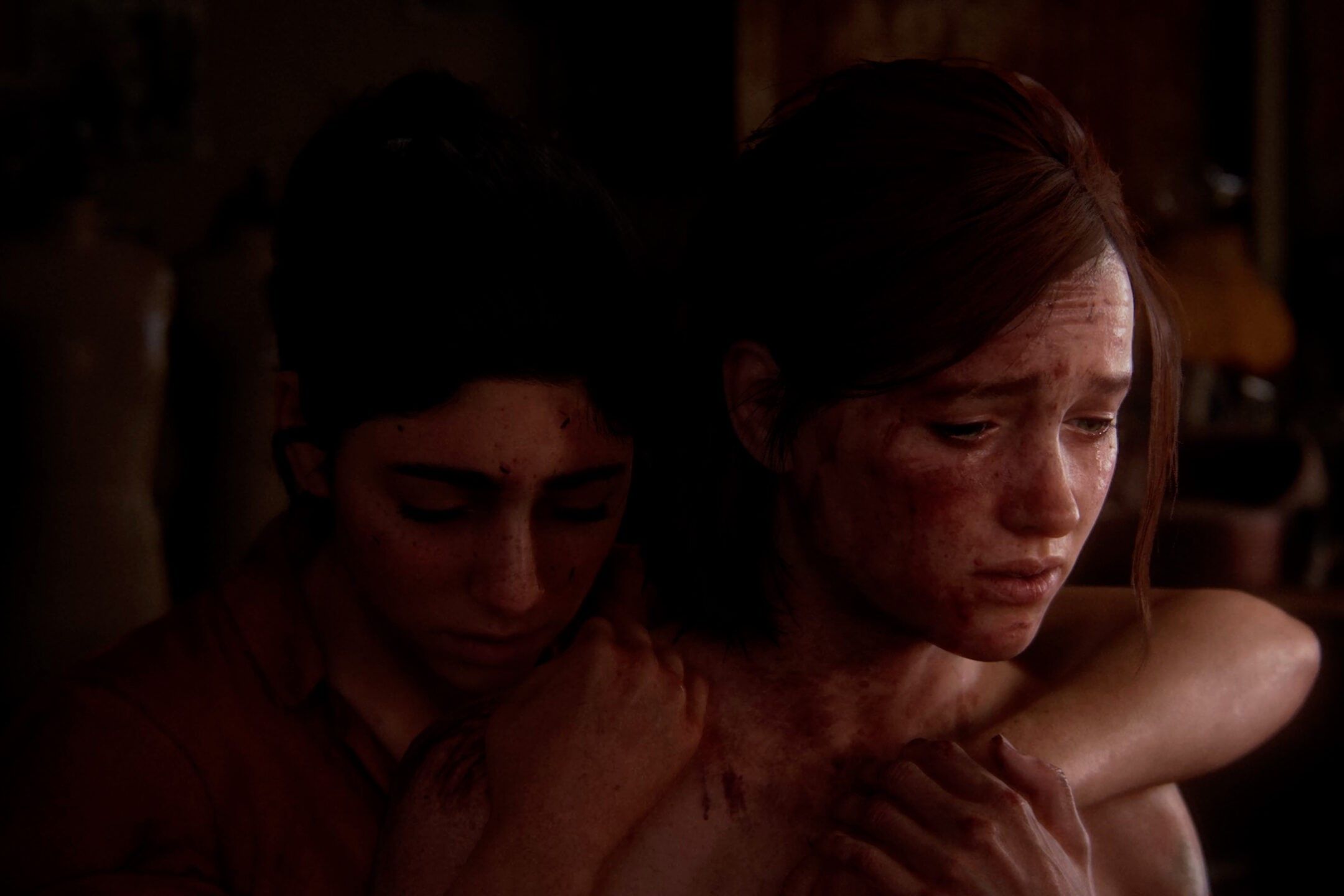Screenshot from The Last of Us Part II showing Ellie and Dina embrace.
