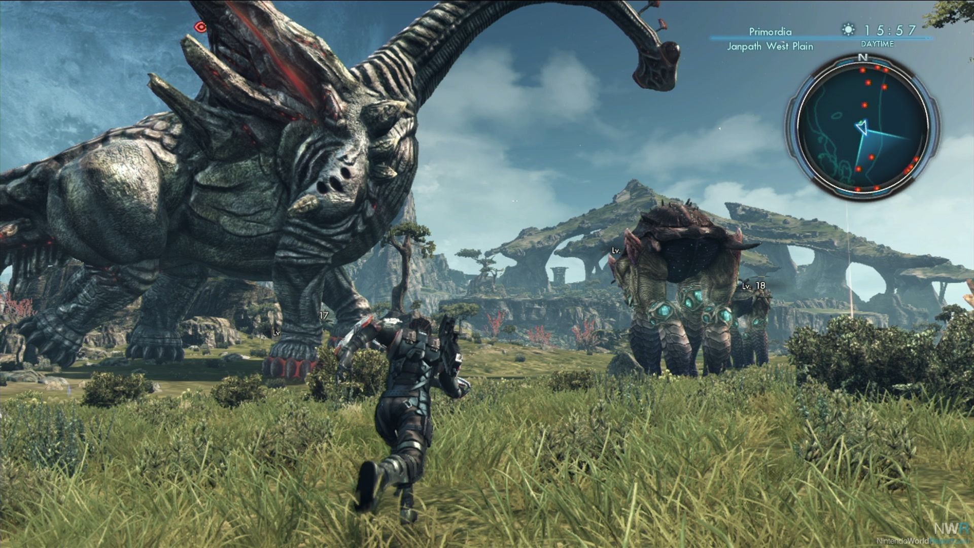 Una captura de pantalla de Xenoblade Chronicles X que muestra a un personaje caminando cerca de monstruos gigantes en un campo abierto.