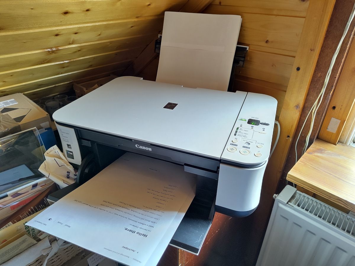 Canon MP 250 printer in the corner with pages printed in tray