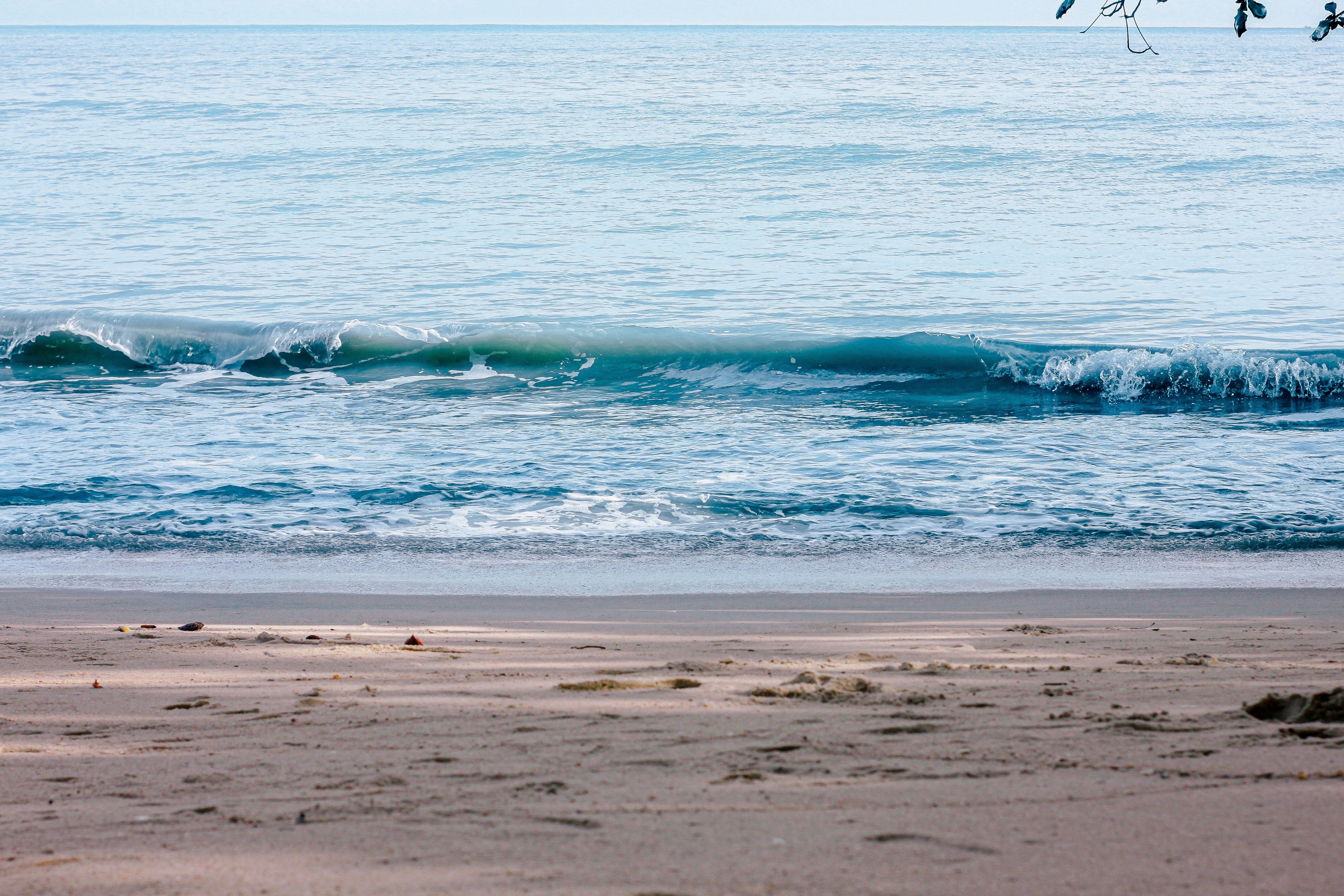 Una foto de una playa con agua hasta el horizonte.