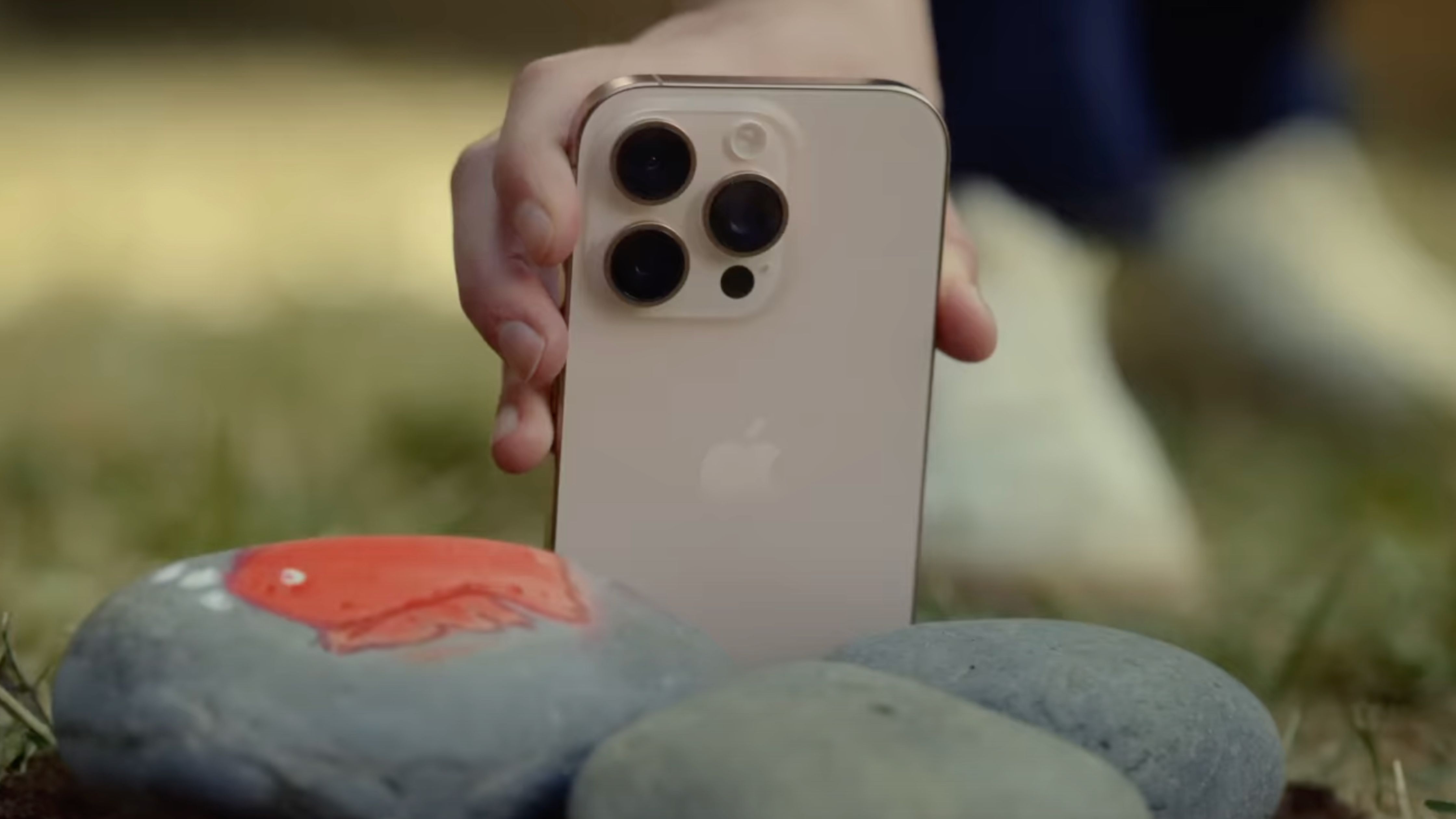 The iPhone 16 Pro design on a rock.