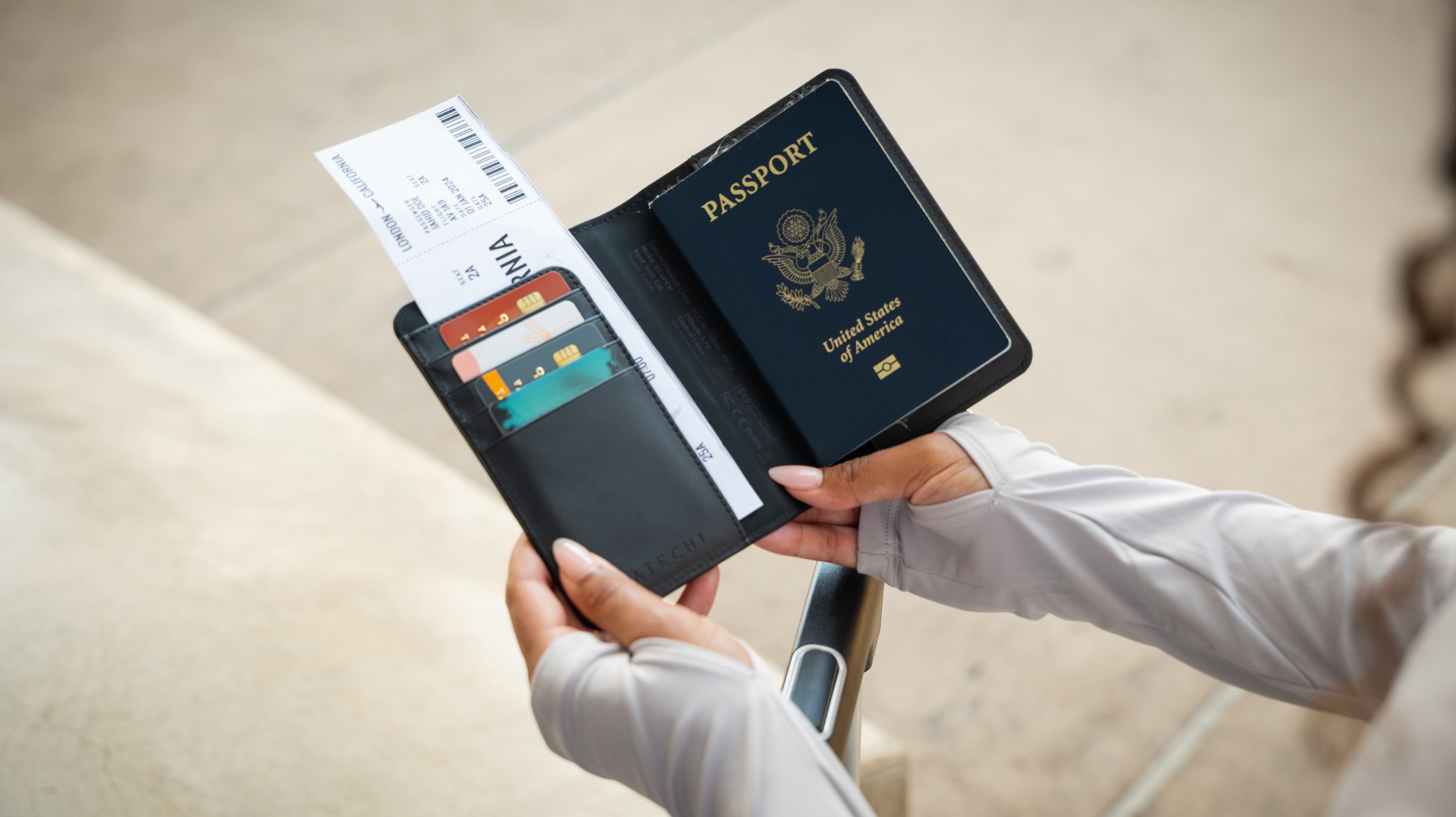 Mujer sosteniendo el porta pasaporte Satechi