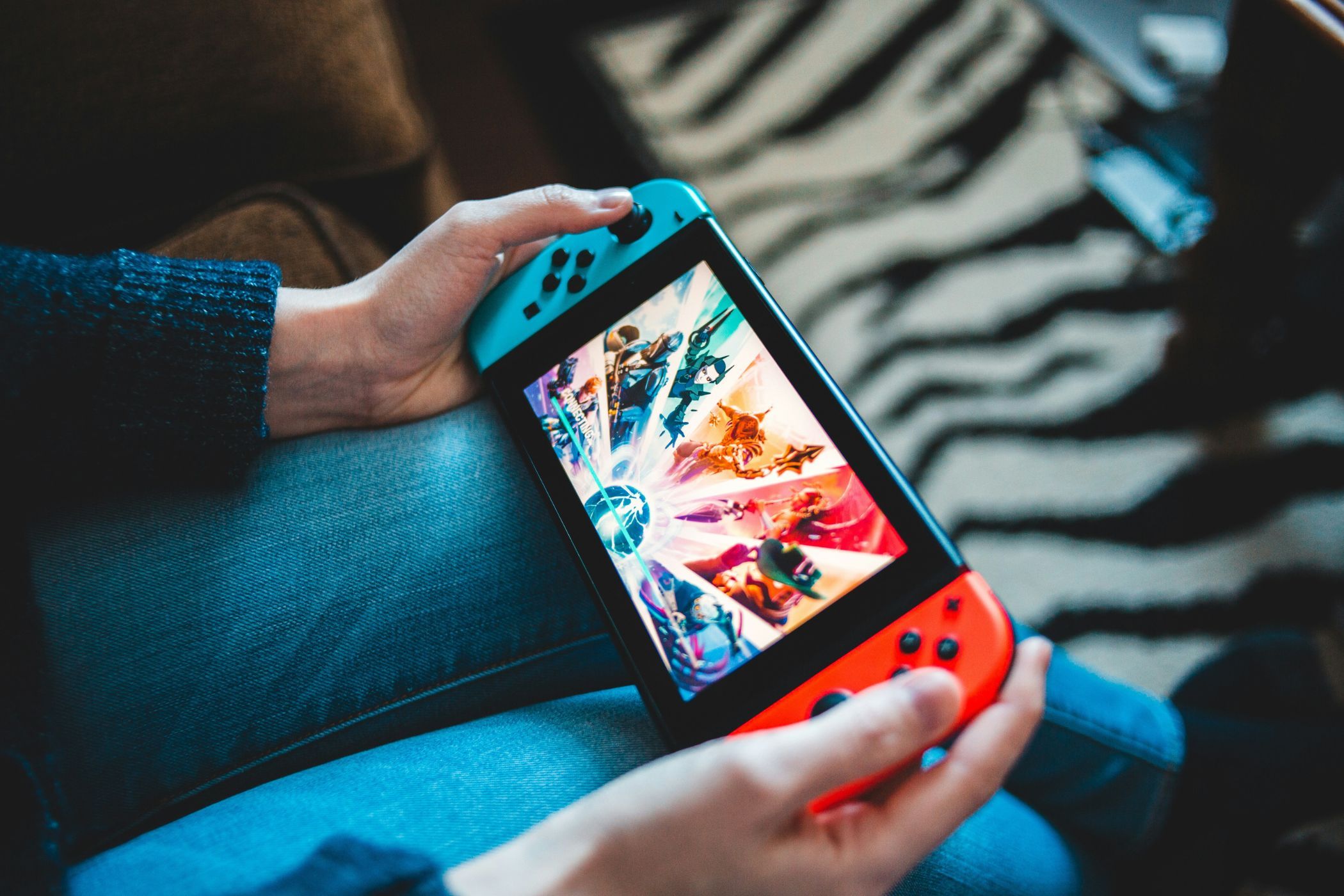 A Nintendo Switch held in the hands of a person.