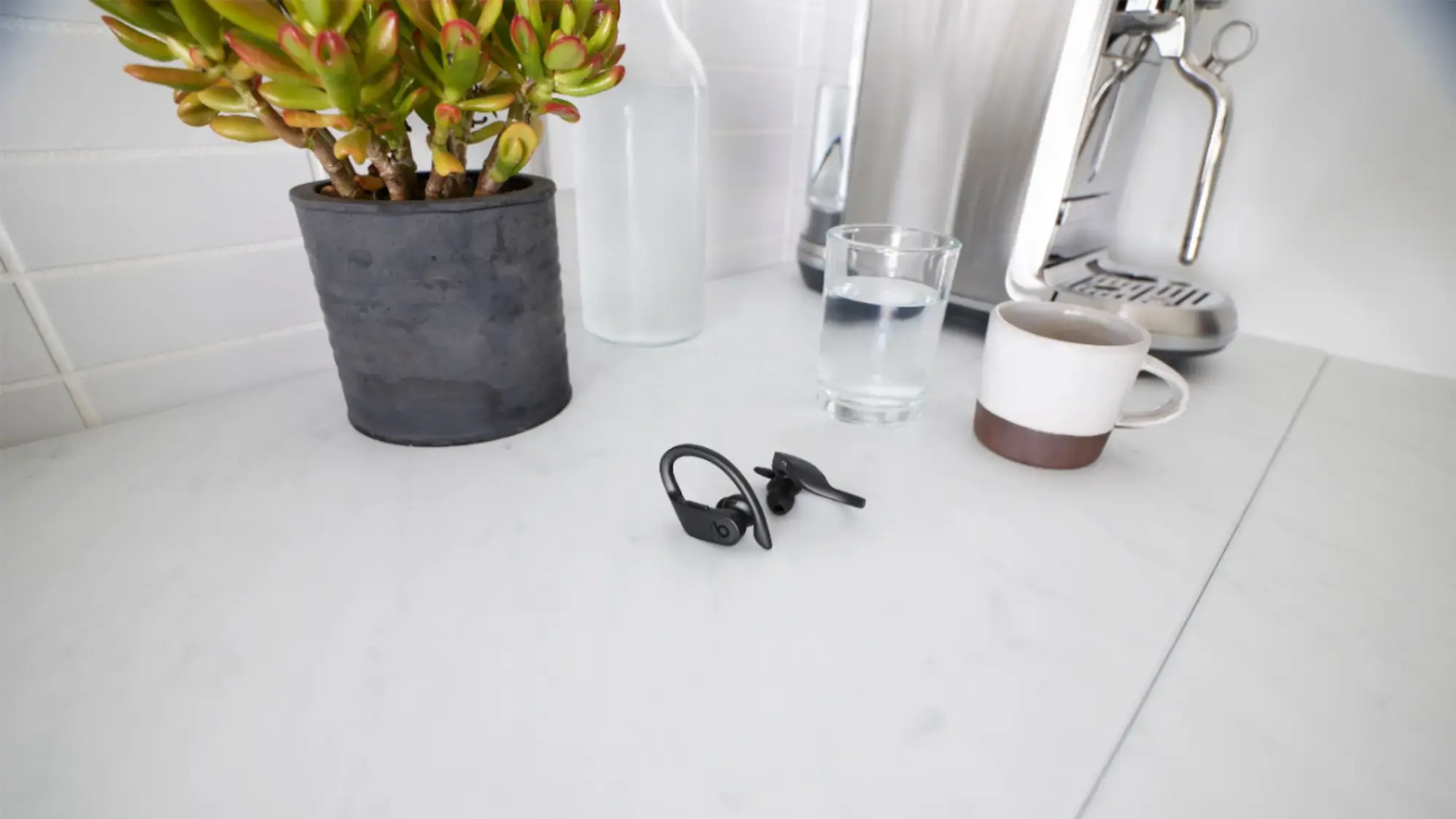 Beats Powerbeats Pro sobre una mesa junto a una planta