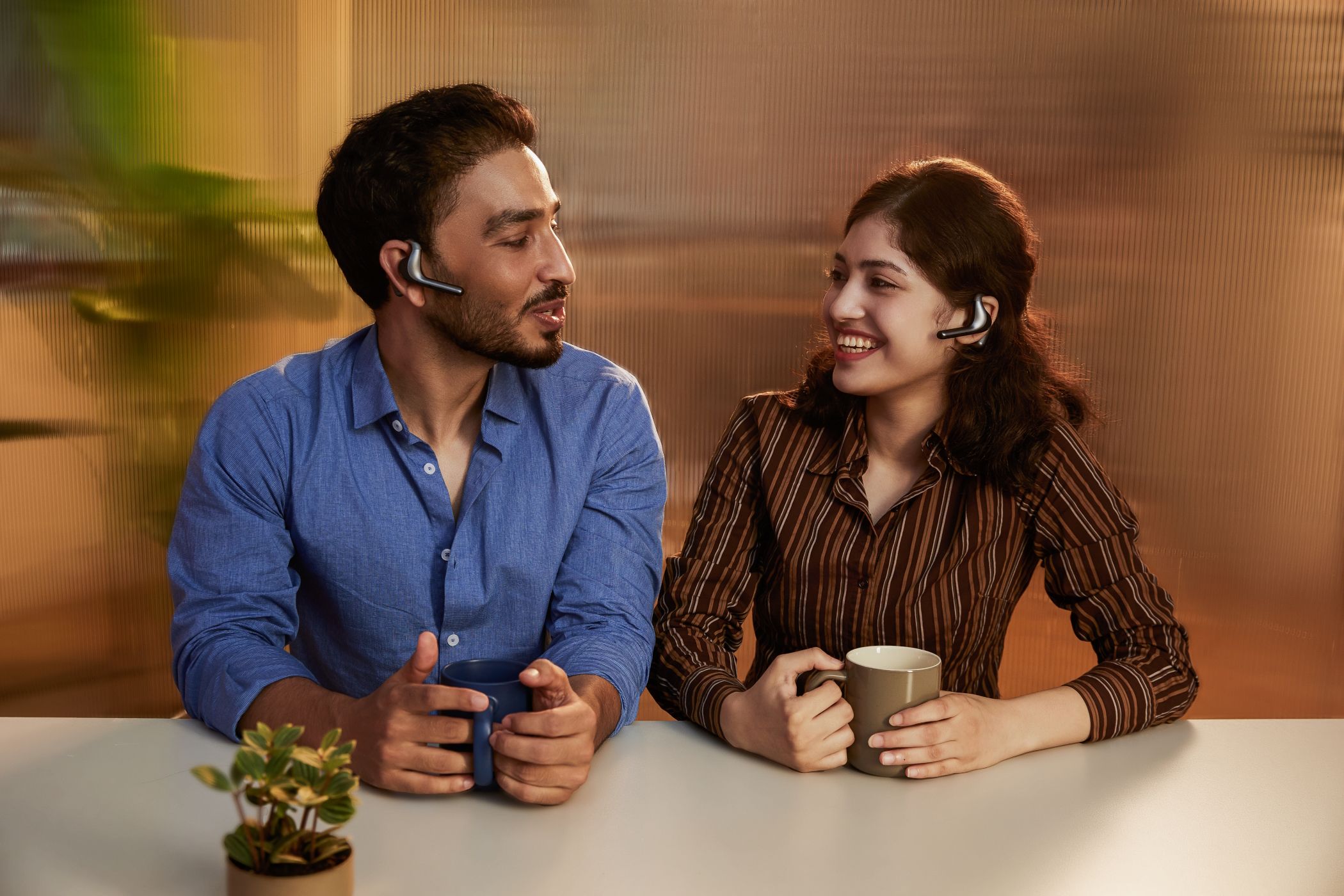 Dos personas con auriculares Timekettle hablando con café