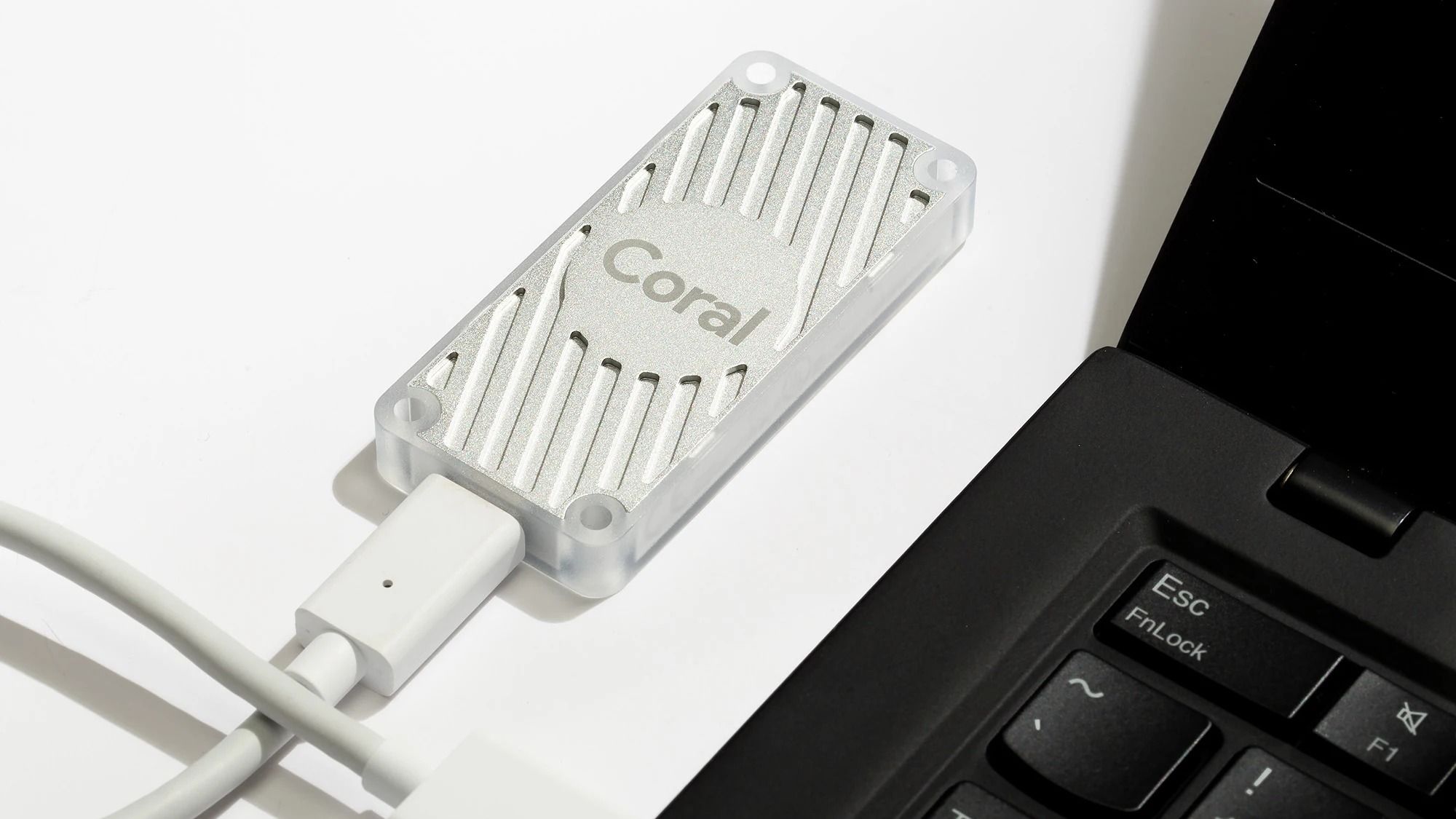 Acelerador USB Coral conectado a una computadora portátil negra