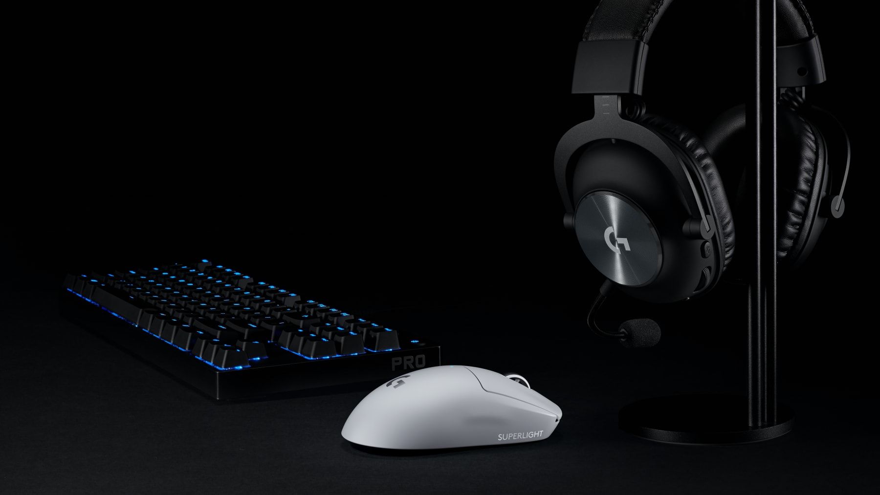 Logitech G PRO X SUPERLIGHT sobre el escritorio cerca del teclado y los auriculares