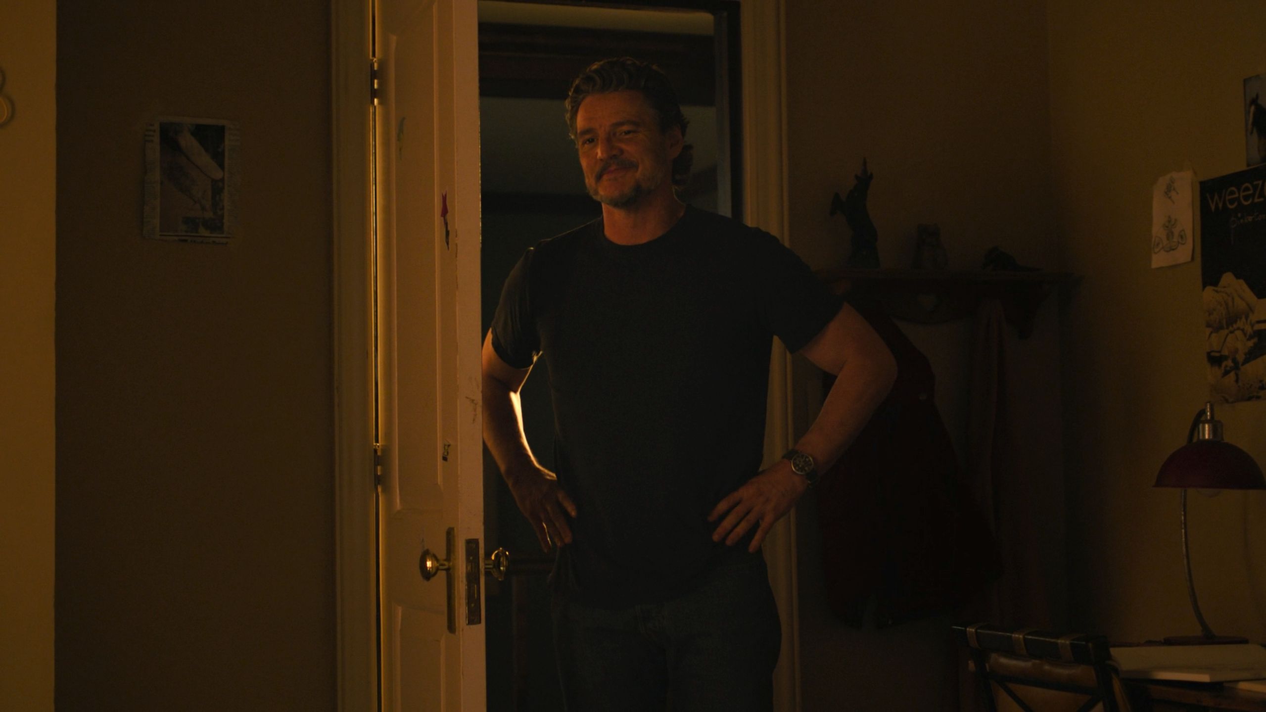 Pedro Pascal as Joel smiling with his hands on his waist in HBO's The Last of Us, season 2, episode 5.