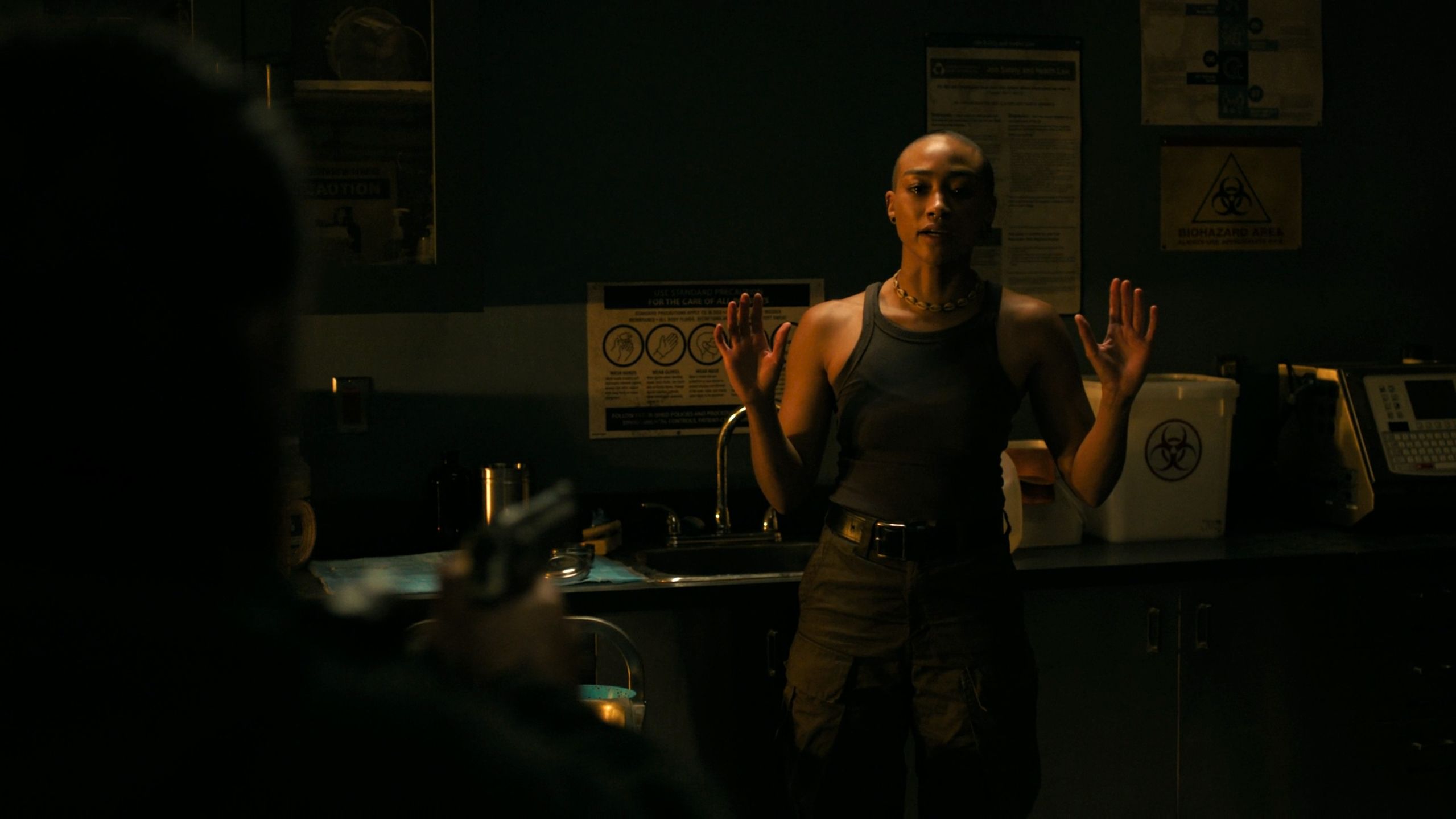 Ellie holding Nora up at gunpoint in HBO's The Last of Us, season 2, episode 5.