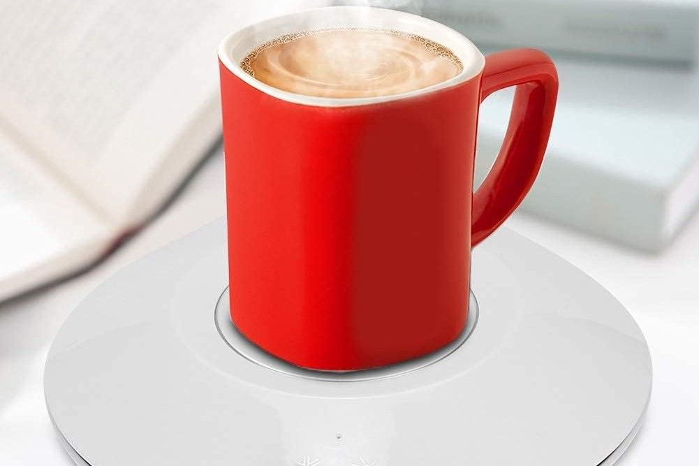 A coffee cup placed on a white heating pad