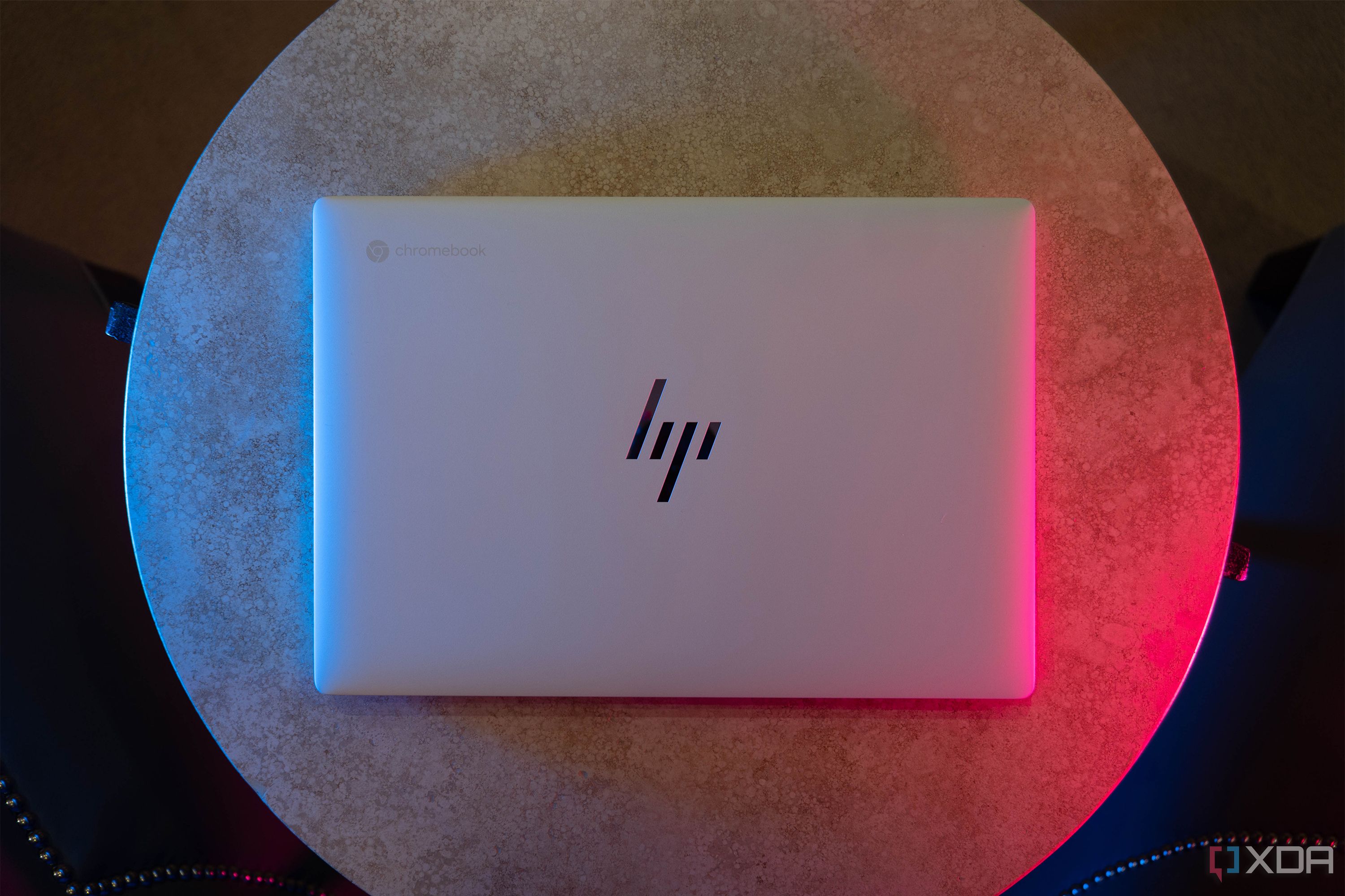 Top down view of white HP laptop with blue and pink lighting
