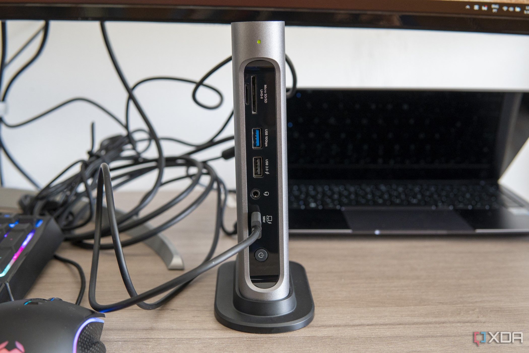 Front view of the Plugable 16-in-1 Thunderbolt 4 Dock in front of a laptop and next to other peripherals on a desk