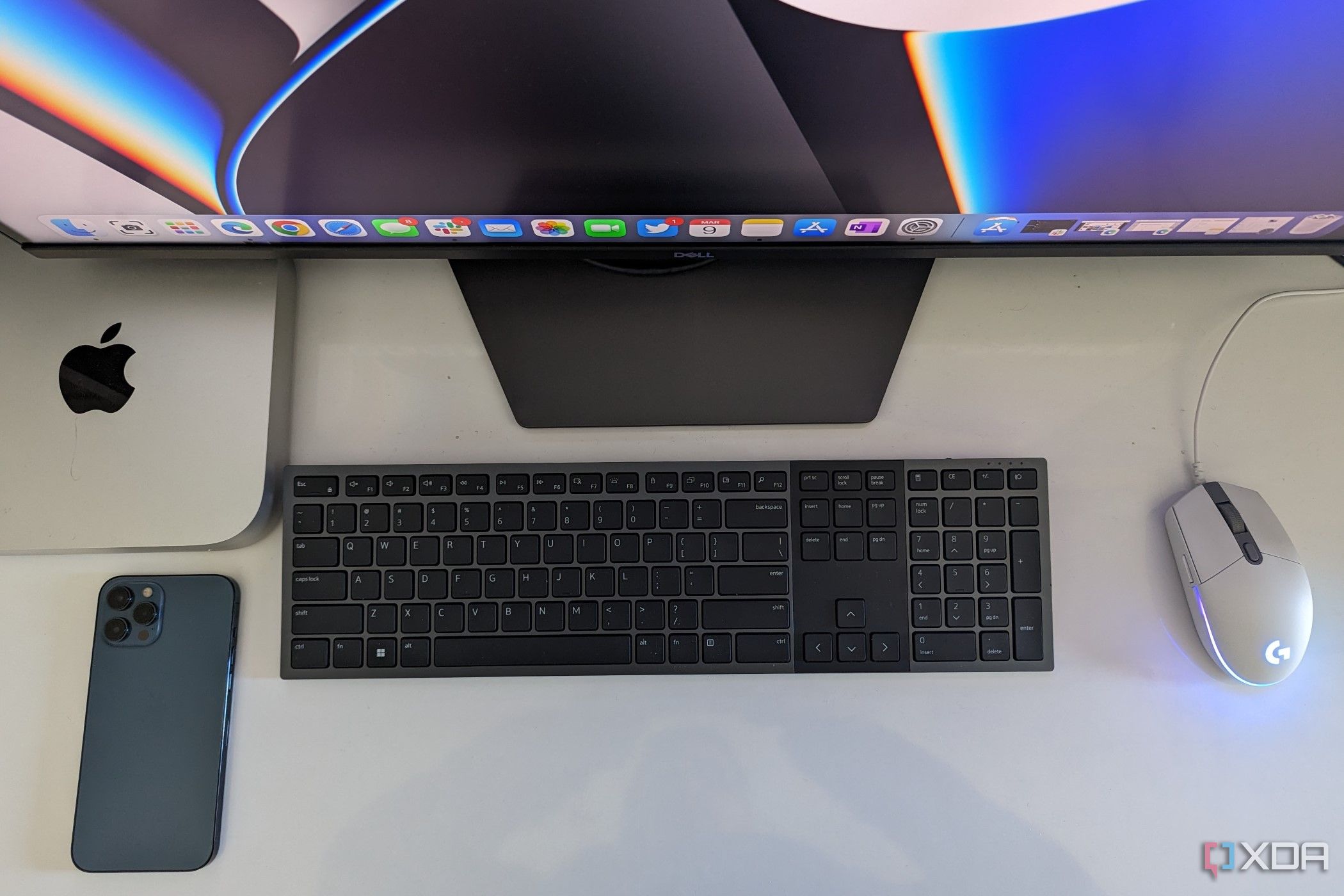 A Mac Mini with keyboard and iPhone