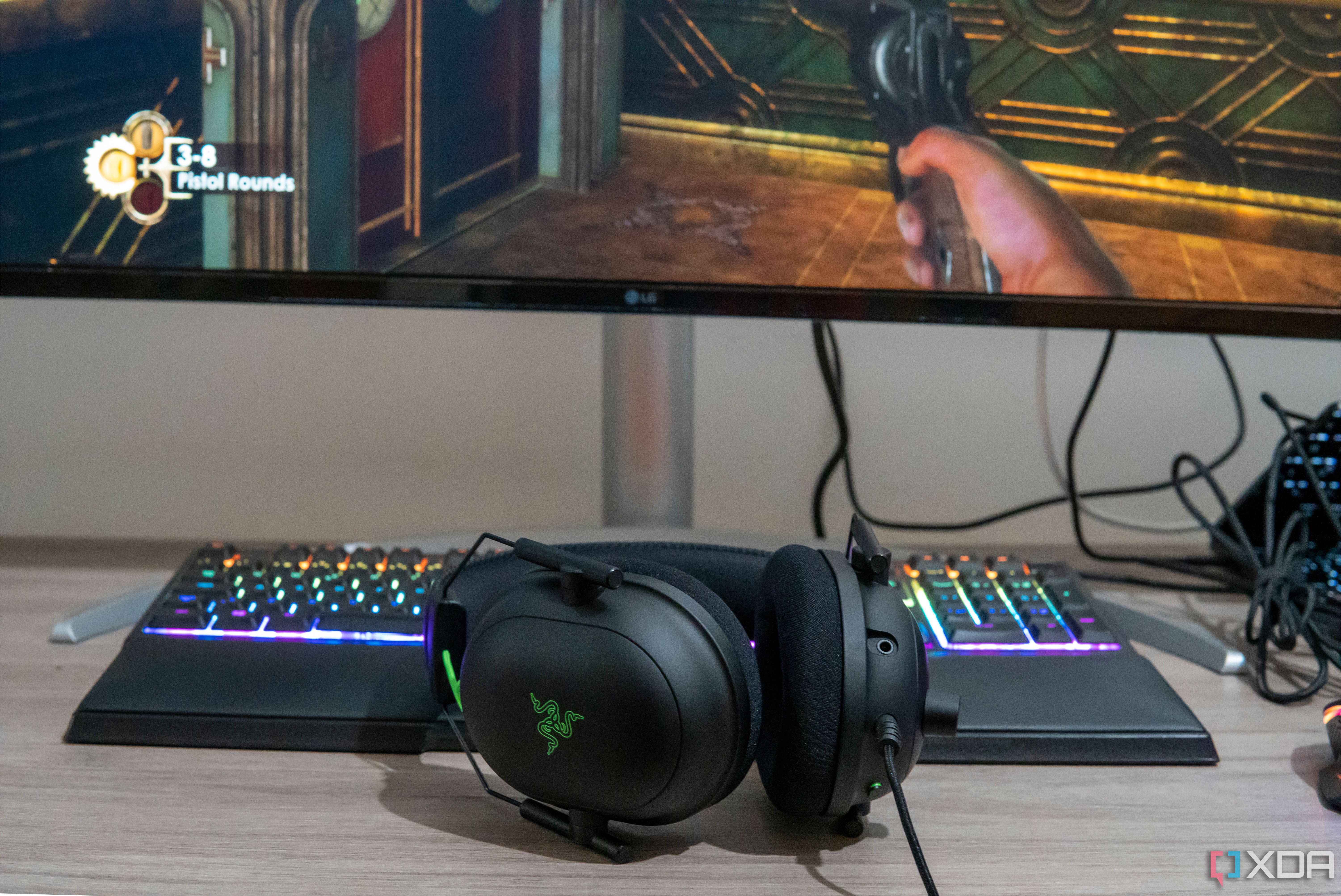 A Razer BlackShark V2 headset next to a cpmputer monitor displaying a videogame