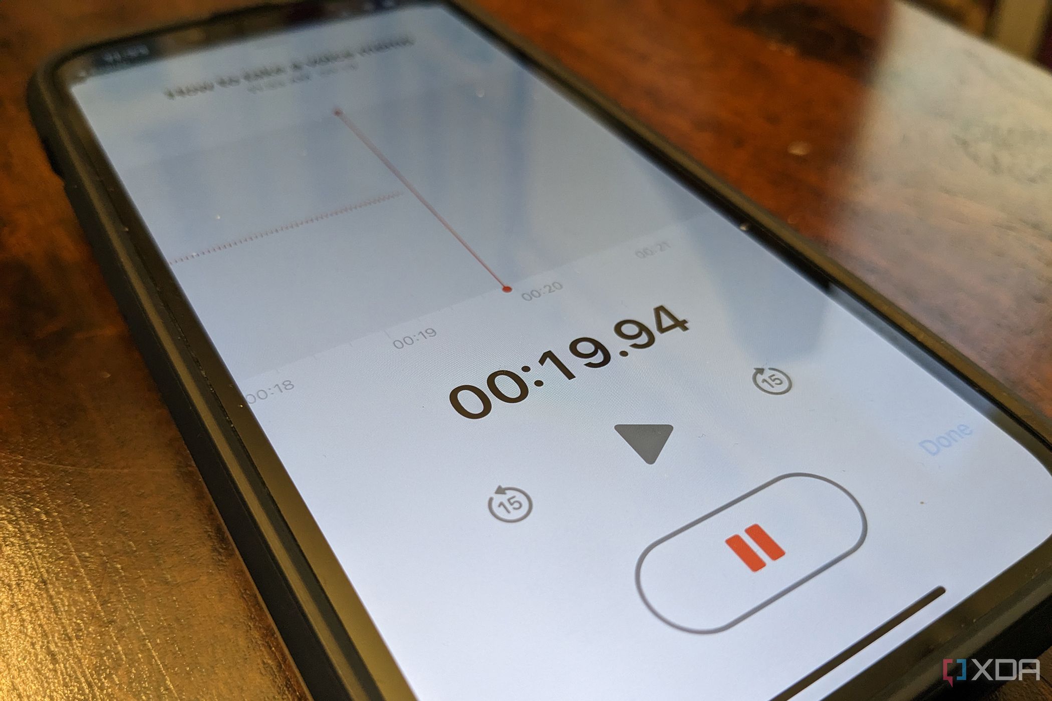 An iPhone on an angle showing a recording in progress in the Voice Memo app.