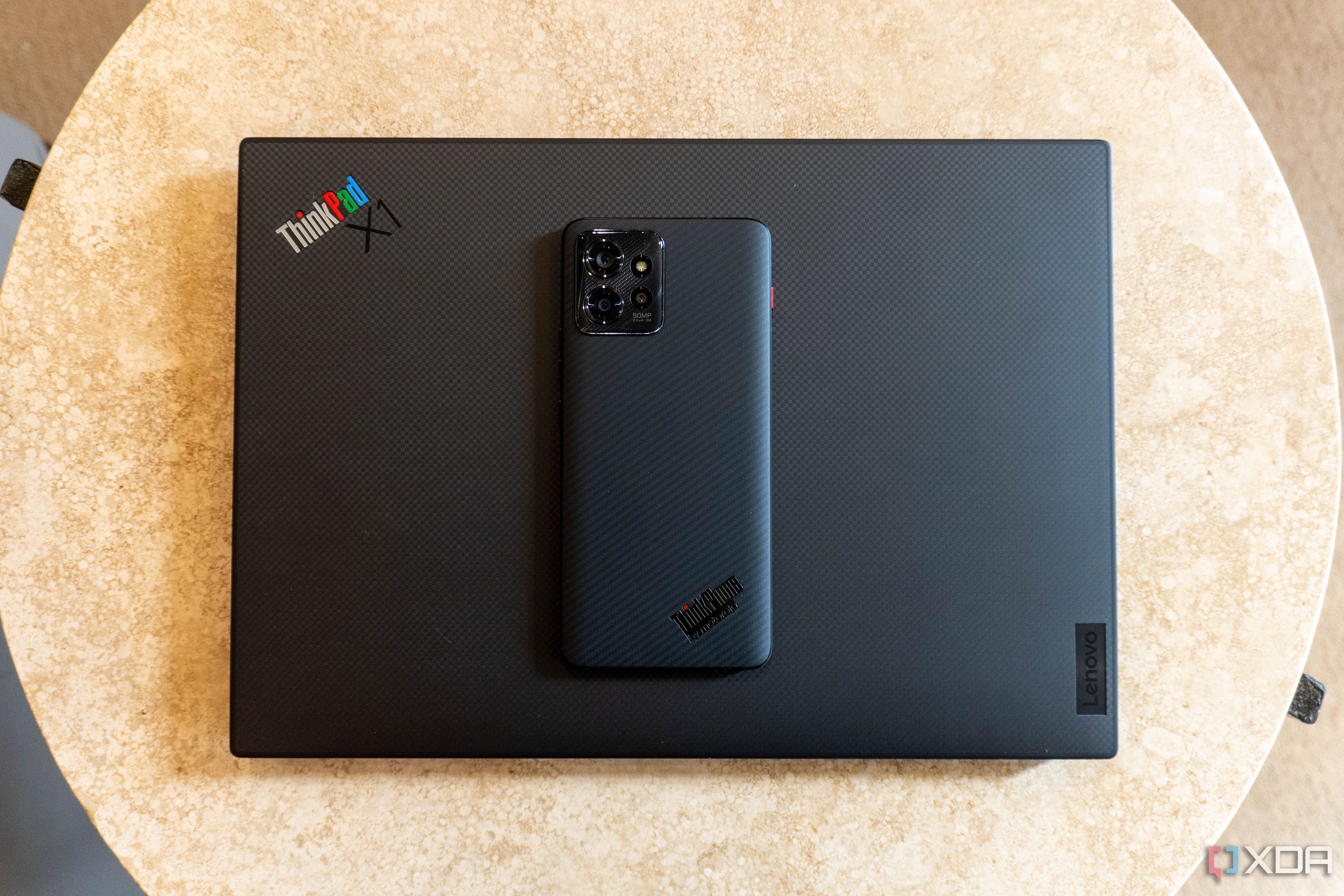 ThinkPhone on top of a ThinkPad laptop